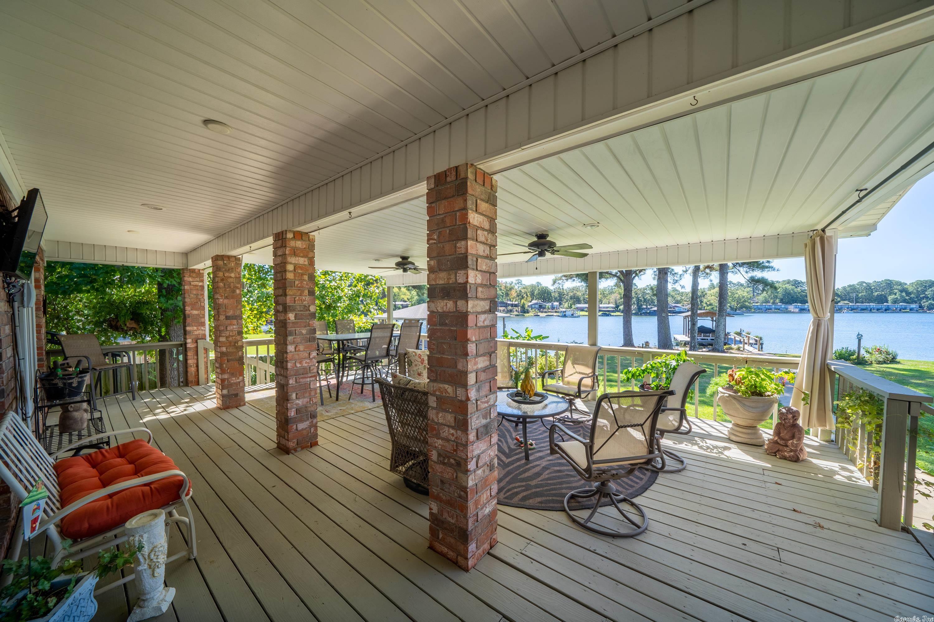 Drive down the private drive to this fabulous updated Southern Living style home! Flat deep lot, approx 160 ft of lake frontage, boat dock, chef's kitchen, large laundry room, tons of built-ins, cedar lined closet, silver closet, sunroom, amazing updated master suite with two walk in closets, two fireplaces, office with wrap around built-ins, extended deck, covered cook area, one large shop with overhead door, two smaller sheds, nice sitting area by the lake, fairly new heat & air and roof, circle drive.