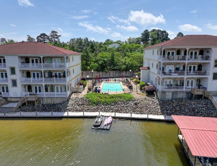 LAKE HAMILTON LUXURY CONDO WITH STUNNING VIEWS!   This spacious 2-bedroom, 2-bath condo overlooking the serene waters of Lake Hamilton is comfortable and elegant. With 1,822 SF, this beautifully designed unit features vaulted ceilings and an open-concept kitchen, dining, and living area.   Spacious master suite has a large walk-in closet and master bath includes a soaking tub and walk-in shower.  Enjoy the well-appointed kitchen with breakfast bar and the wet bar in the dining area—ideal for entertaining. The spacious living room includes a cozy fireplace and surround sound system, perfect for relaxing evenings.  Step out onto the covered balcony to take in breathtaking lake and mountain views, whether you're enjoying your morning coffee or evening wine.  Additional highlights include:  - Covered boat slip   - 2-stall covered parking near the elevator   - Security system   - BRAND NEW HVAC with a 10-year transferable warranty   - Elevator access within the complex   - In ground pool overlooking Lake Hamilton   This condo offers comfortable and tranquil lakeside living and is move-in ready!   COME AND SEE!  Agents - please schedule all showings through Showing service.