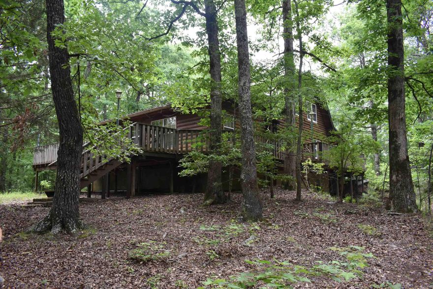 Tucked into a grove of mature hardwood timber, this real log home on 4 +/- acres has many great features. The 2864 +/- Square foot home boasts three beds and two baths, porches, decks, and outdoor storage areas. Being located just down the road from the Caddo River, and near the Ouachita National Forest, this acreage is an outdoorsman’s dream and in a perfect location. The real log home is just that, not a log siding home, but a home with true log construction. The main level of the two-story home has a den, a large living area that could easily be converted into another bedroom, eat in kitchen, and a full bathroom. Upstairs, two bedrooms and a full bathroom as well as large closets provide plenty of space for the whole family.  • 2864 +/- Square Foot Real Log Home • 3 beds 2 baths • 4 +/- Acres • Ouachita National Forest Nearby • Minutes from the Caddo River • Detached two car garage • Multiple storage buildings • Walk out basement • Wood stove • Porches and Decks on three sides • Mature timber • Great Views • Good Topography • Private and Secluded • 20 Minutes from Glenwood • 15 Minutes to Caddo Gap