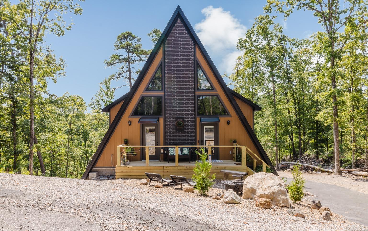 This incredible home is a custom built 3 story A-Frame with a detached garage/shop. This one is truly a must see to appreciate the accomodationg size and tranquility that it offers. Upon entry from the deck at the front of the home you are greeted with a beautiful open concept living area with 30' vaulted tongue and groove ceilings that open to the grand loft above with a view of a custom built live wood bannister, not to mention the gorgeous fireplace centered from floor to ceiling that brings the whole space together. The kitchen is a chef's dream with custom built cabinets, a 6 burner gas cooktop, top of the line SS appliances and tons of storage space. On this level you will also find the half bath/upstairs laundry room and the Primary Suite with custom details and a Primary bathroom that is timeless as it is unique with a soaker tub and walk in tile shower. The loft is a large open space with many possibilities including bedroom space, it includes 1 of the 3 full size bathrooms with a walk in tile shower. The basement level offers a complete 2nd living space with full kitchen, bathroom and laundry. Also including over 500 sq ft of H/C partially finished space. Don't Miss It!!!