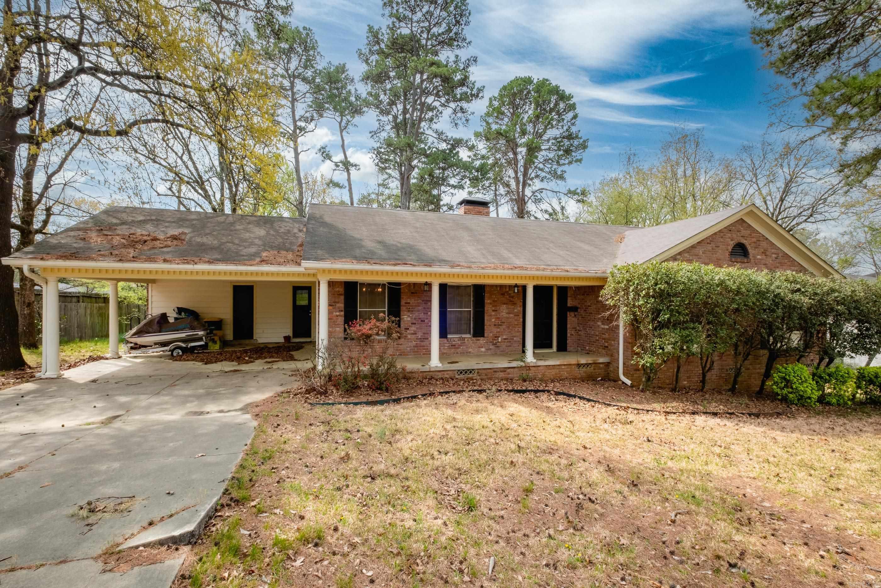 Charming 4-bed, 3-bath home in Little Rock, AR, offering 2,466 sq ft of spacious living! This brick ranch features a large covered front porch, perfect for relaxing. Inside, enjoy hardwood floors, a cozy brick fireplace, and an open layout connecting the living, dining, and kitchen areas. The kitchen boasts wood cabinetry, stainless steel appliances, and ample counter space. Three bedrooms are upstairs, while one bedroom downstairs includes its own door to the backyard and a private bathroom—ideal for guests or in-laws. Two additional full bathrooms feature vintage pink tiling, adding character. The expansive lot offers a mix of lawn and mature trees, with a driveway and carport for parking. This home is brimming with potential for updates in your style! New leaf guard gutters installed. Located in a serene neighborhood with easy access to Little Rock’s amenities, this property is perfect for those seeking space and charm. Don’t miss this opportunity to make it your own! Schedule a showing today. Agents See Remarks.