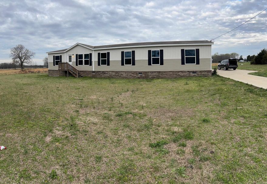 Very nice double wide on permanent brick foundation with huge covered back deck and built on carport area, concrete driveway, partial fenced yard.  Double wide has wonderful floor plan with many options for bedrooms, office area,  living areas, butlers pantry, island in kitchen, split bedroom plan with nice master suite, 3 full bathrooms.  located on paved road with quick access to the interstate.  Extra features throughout giving the home a welcoming atmosphere and lots of space.