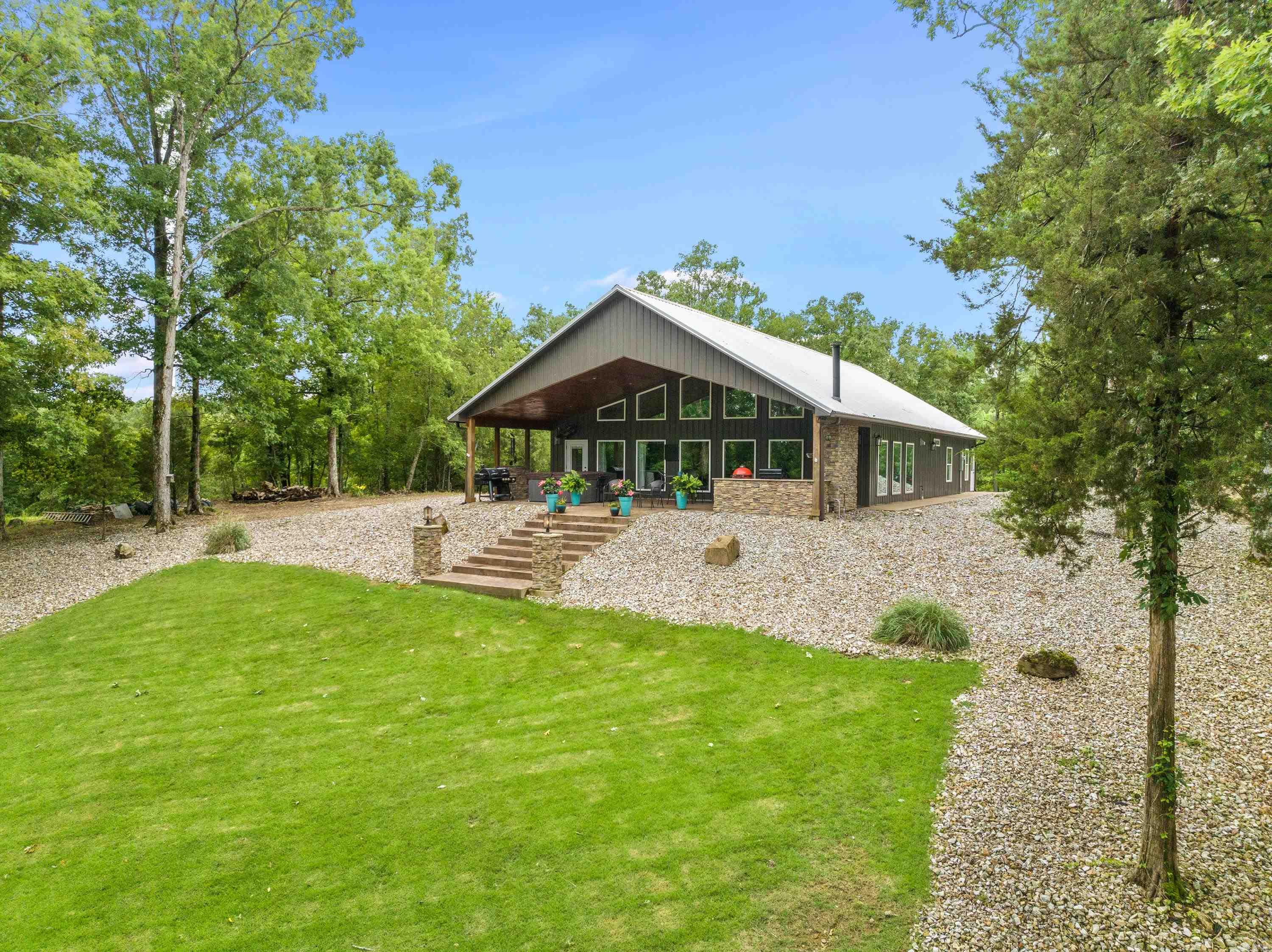 Welcome to your lakeside oasis! Nestled on a serene 3-acre lot, this beautiful lake house offers the perfect blend of luxury, comfort, and breathtaking natural beauty. Step onto the expansive 16x40ft patio living area and immerse yourself in peace. Whether you're unwinding in the bubbling hot tub or cozying up by the fireplace, this outdoor space is an entertainer's dream and a sanctuary for relaxation. Inside, the charm continues with a double-sided fireplace gracing both the spacious living room and the elegant primary room. Enjoy the warmth and ambiance on cool evenings as you relax in this inviting retreat. the most captivating feature of this property is the stunning views that greet you from every angle. Whether you're enjoying your morning coffee on the patio or lounging in the primary room, panoramic views of the shimmering lake and lush surroundings never fail to inspire. For water enthusiasts, this home comes with a covered boat dock, complete with two lifts and a convenient swim deck. After spending your days boating, fishing, or simply soaking up the sun on Lake Hamilton. A concrete patio area by the boat dock welcomes you home to a perfect spot for lakeside gatherings.