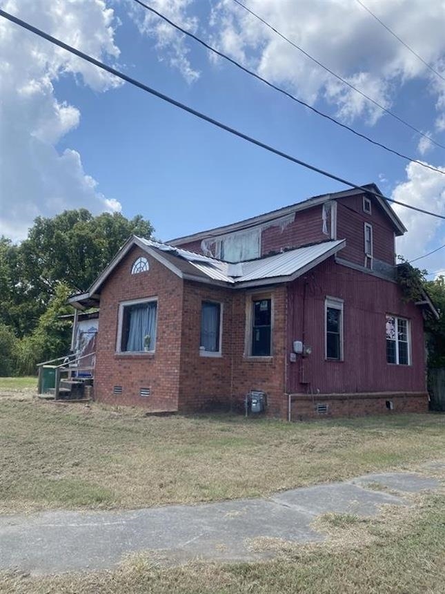 Investors - take note! This is definitely a fixer upper - but has great bones on a corner lot. Some of the work has been started: metal roof, some of the central heat and air, garage has been closed in to make an additional room, some windows are new and a plumbing leak from the second floor was repaired. This project is just waiting for you and your vision!