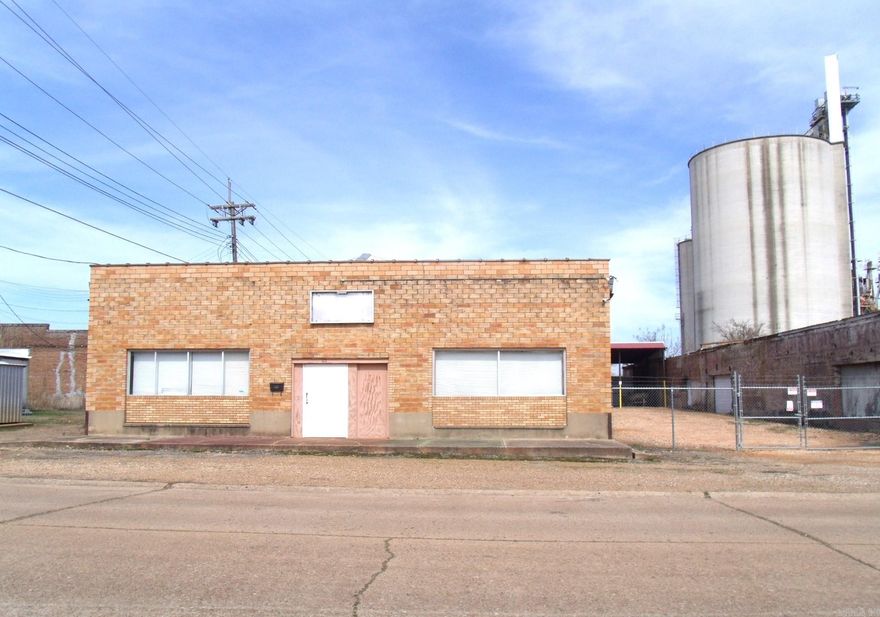 Commerical Building with tons of business opportunities.  Over 8750 square feet with several front office space areas. Large warehouse area with divided areas, shelving, upstairs storage area, two stall bathrooms, Bay Door 12'x12'.  Fire Sprinkler System, Security System, fenced in area with three covered bay areas Height 15' 5", Width 11'6" and 41' depth, great for rental income.  New windows installed to front of building.  Second building has no value, but the land could be used for multiple things.