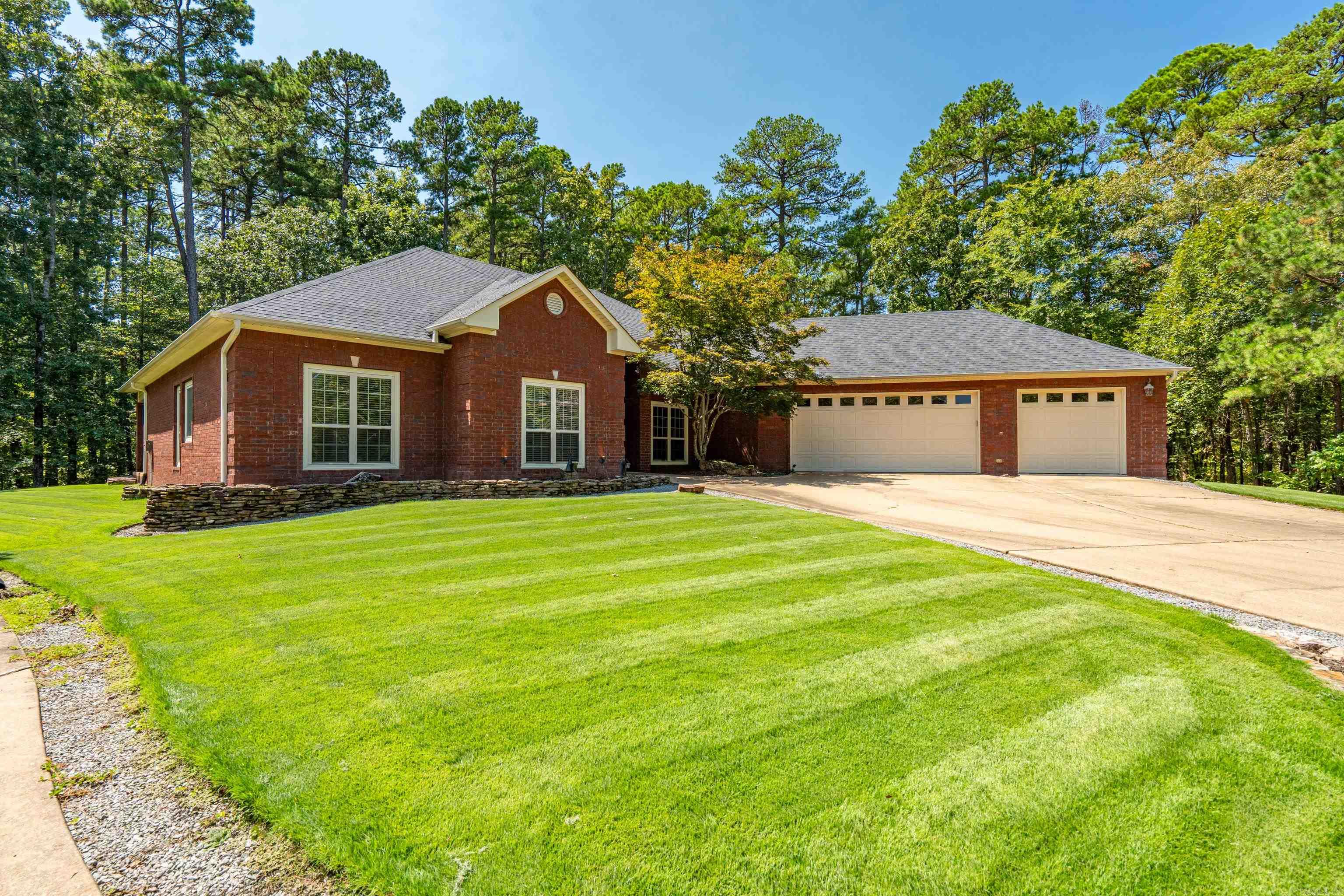 This one-of-a-kind property in located in the heart of security gated Hot Springs Village, AR. Minutes to the health club, golfing, boating, hiking trails, restaurants, etc. This unique property ALSO has the lot next to it that boasts an incredible 2,336 SqFt RV-Garage, with a 56' bay, 13'9' motor home door, room to store your boat, vintage cars, or make it a huge workshop, complete with office & full bathroom. The outside is beautifully designed to match the home! This all brick home features designer worthy touches & upgrades. Hickory floors in the living areas, custom tile work, maple cabinetry in the kitchen & laundry. An office with dual-seating & custom built-ins, an extra room on the primary bedroom side of the home that has many possibilities: craft-quilting room, library, card room, create another large closet, exercise room..so many possibilities! The home is the only home on the cul-de-sac, so no neighbors on either side! The backyard has a covered patio deck, perfect for sitting outside at night, add a firepit for some great conversations & memories. The home has a 3-car garage with newer epoxy floors, a half-bath and direct entry into the home. AGENTS SEE REMARKS