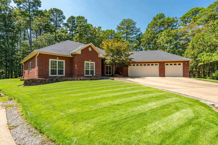 This one-of-a-kind property in located in the heart of security gated Hot Springs Village, AR. Minutes to the health club, golfing, boating, hiking trails, restaurants, etc.  This unique property ALSO has the lot next to it that boasts an incredible 2,336 SqFt RV-Garage, with a 56' bay, 13'9' motor home door, room to store your boat, cars, a huge workshop, insulated complete with office & full bathroom.  The outside is beautifully designed to match the home! This all brick home features designer worthy touches & upgrades.  Hickory floors in the living areas, custom tile work, maple cabinetry in the kitchen & laundry.  An office with dual-seating & custom built-ins, an extra room on the primary bedroom side of the home that has many possibilities: craft-quilting room, library, card room, create another large closet, exercise room..so many possibilities! The home is the only home on the cul-de-sac, so no neighbors on either side!  The backyard has a covered patio deck, perfect for sitting outside at night, add a firepit for some great conversations & memories.  The home has a 3-car garage with newer epoxy floors, a half-bath and direct entry into the home. AGENTS SEE REMARKS