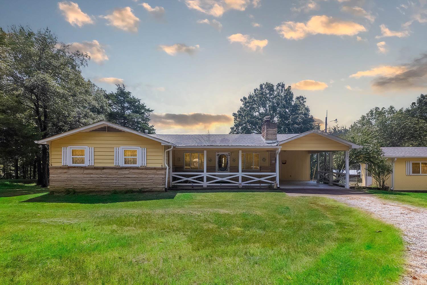 Hobby Farm For Sale in the Ozarks Enjoy the charm of country living with this 3-bedroom, 3-bath home situated on 11± acres in the heart of the Ozarks. The home features a spacious open living area with a wood stove and both front and back covered porches, perfect for gatherings or quiet evenings outdoors. Many recent updates add peace of mind, including a new roof, HVAC system, windows, water heater, and updated bathroom flooring. A one-car carport provides additional convenience. The property includes a variety of outbuildings to fit your lifestyle needs: a horse barn with tack room, a detached garage, a well house, and a multipurpose outbuilding with guest quarters and workshop space. The land offers a mix of open ground and 5± wooded acres, along with a pond that adds to the natural setting. Located just minutes from the Spring River and Salem, and only a short drive to Ash Flat, this property provides the best of both worlds—peaceful seclusion with easy access to town. All of this is located on a paved county road!