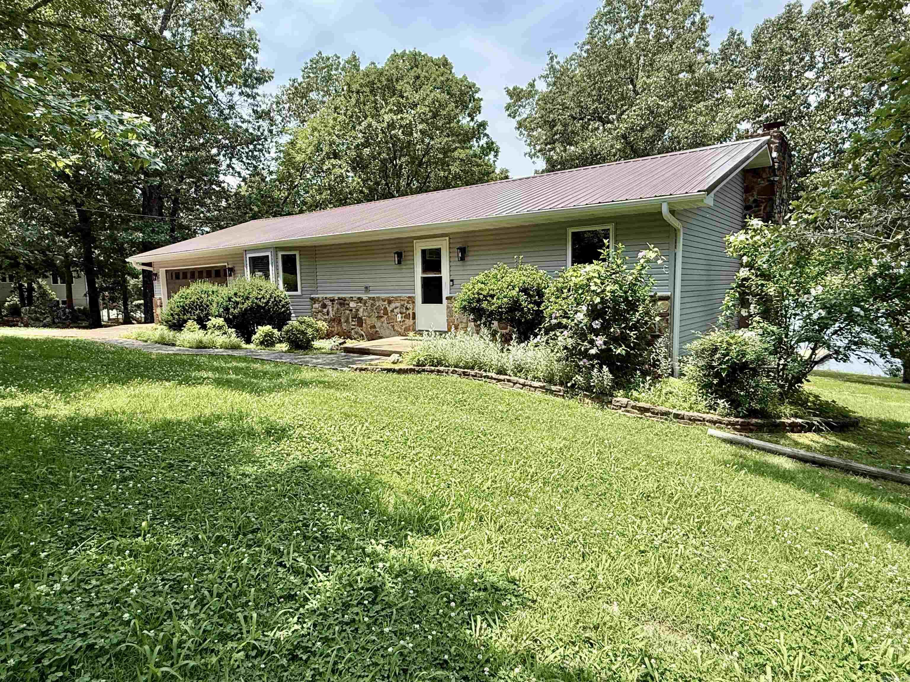 This completely remodeled 4-bedroom, 3-bathroom home is situated on approximately 1 acre along the south side of the beautiful 645-acre Crown Lake. It resides in the South Shore subdivision on lots 20 and 21 of Horseshoe Bend, Arkansas. With a brand-new metal roof and thoughtful updates throughout, this home is move-in ready and ideal for year-round living or a relaxing vacation getaway. Inside, youāll find two bedrooms on each level, including spacious master suites both upstairs and in the basement. The large kitchen features a breakfast bar and opens to a light-filled living area, where expansive windows capture stunning lake views. Step out onto the lakeside back porch and enjoy peaceful mornings or vibrant sunsets over the water. Conveniently located just minutes from the heart of town, youāll have easy access to local shops, restaurants, and amenities. Whether you're looking for a permanent residence, or a weekend vacation home, this Crown Lake home can be yoursāall for $469,900.