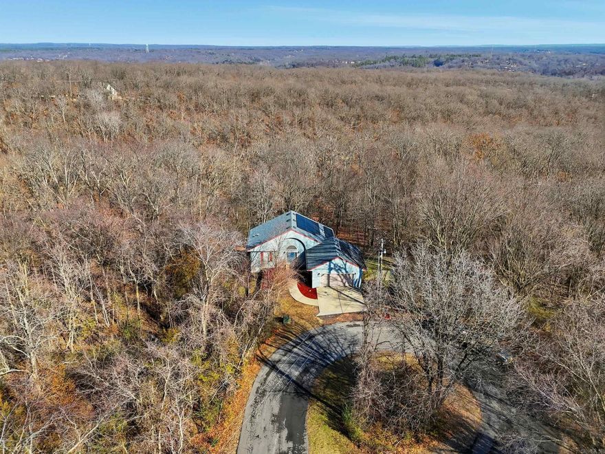 Prime Bella Vista Location! Just 12 minutes to Walmart Home Office, located at the end of a quiet street, surrounded by acres of woods and direct MTB trail access, this spacious home offers 4 bedrooms and 2.5 baths, plus a family room, office, and an impressive oversized workshop. The living room showcases soaring ceilings and abundant natural light from expansive windows. A large second laundry room on the main level provides excellent flexibility and could easily serve as a craft room or additional indoor storage. Enjoy peaceful views of the woods from the double rear decks. Tucked away on a private cul-de-sac lot, this home offers exceptional privacy and abundant wildlife. The kitchen features generous counter space, a breakfast bar, pantry, pull-out shelving, and a built-in desk area. The lower-level workshop, located beneath the garage, includes double exterior doors perfect for hobbies, projects, or a dedicated workspace. Solar panels will be paid off at closing, saving you an exceptional amount on your utilities monthly. Schedule your showing today!