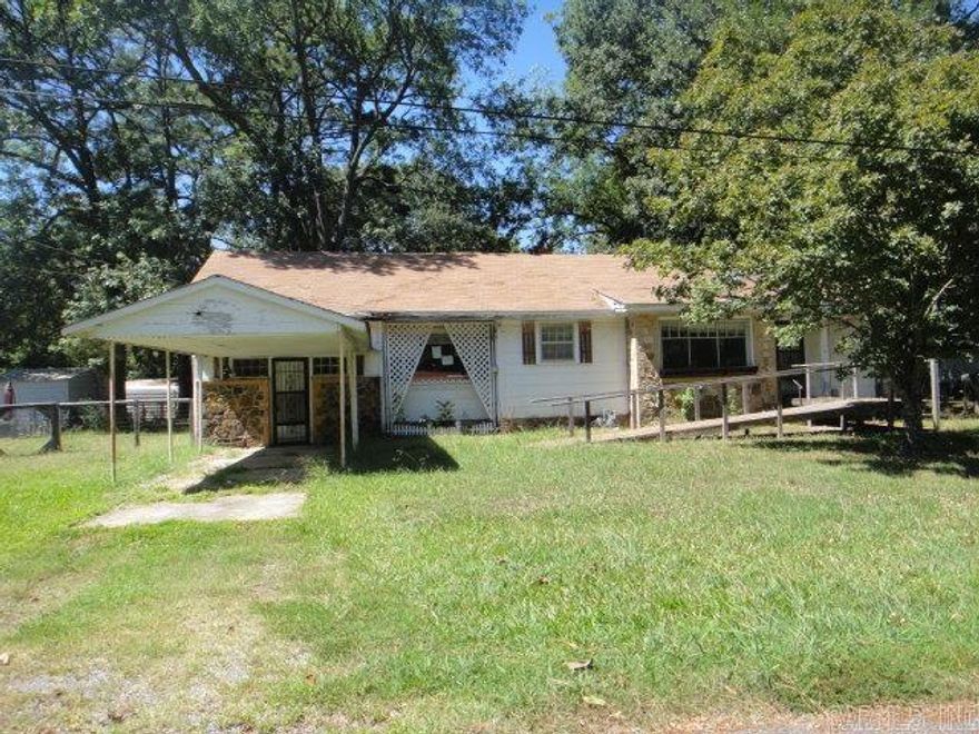 Rock and frame house has a fenced back yard, large LR, Bonus Rm and Dining Rm. Also, closed in back porch. Original wood floors in Living Rm.  See agent remarks