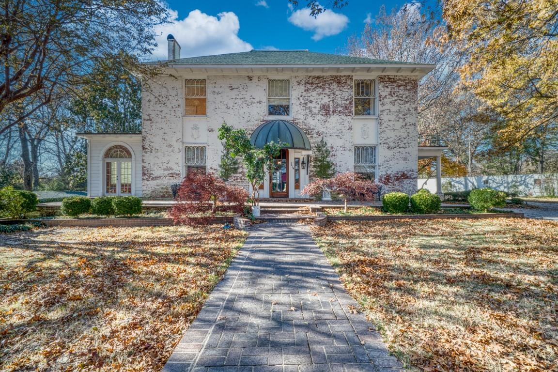 This historic 1903 home sits on 1.22 acres along South Main Street, surrounded by a white cinder block wall. The terraced grounds feature a large circular drive, three-car garage with workroom, raised garden, in-ground pool with two pool houses, a putting green, and a custom jungle gym nestled among two stunning magnolias. Just one block from Jonesboro High School, this 4-bedroom, 3.5-bath home offers 4,520 sq. ft. of living space, plus an 896 sq. ft. basement with a full bath, ideal for play, storage, or storm safety. The main floor boasts large rooms with high ceilings, including a living room with fireplace, sunroom, dining room, walnut-trimmed den, and screened porch. The chef's kitchen features a Thermador 6-burner gas cooktop, double oven, onyx backsplash, and a huge pantry. Upstairs, the master suite and three additional bedrooms share spacious closets and a second bath. This landmark property offers a unique chance to own a piece of local history.