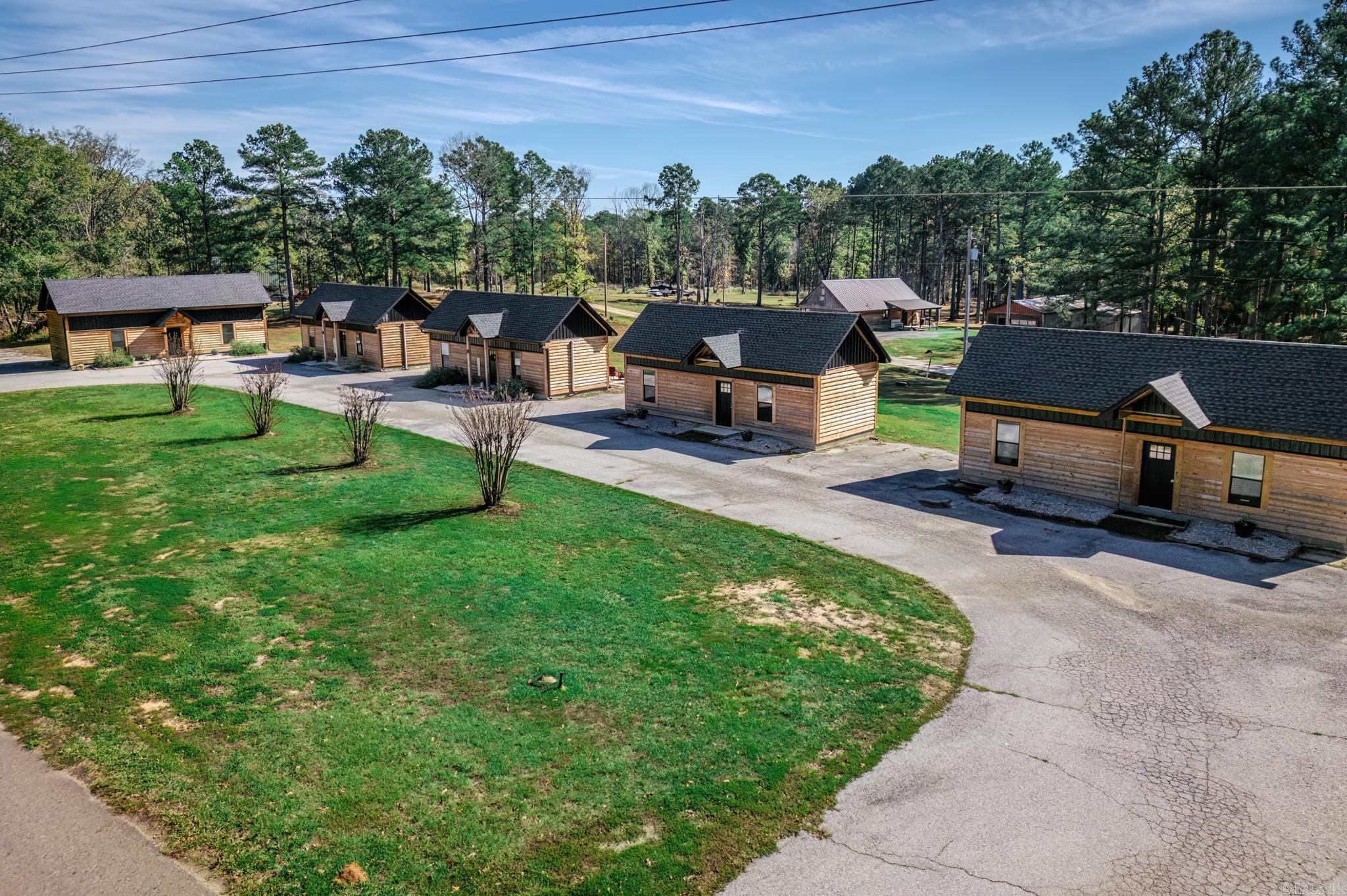 Seize this unique investment opportunity with six newly constructed cabins on 3 acres, ideally located next to Core of Engineers land and just one mile from the Arlie Moore boat ramp on DeGray Lake. Each cabin offers 1 bedroom, a beautiful oversized loft area, a full bathroom, and an inviting open-concept kitchen and dining area, complete with an electric fireplace for added charm. Currently being used as short-term rentals, the property is perfectly situated only 20 miles from Oaklawn Racetrack and Casino as well as Arkadelphia, home to both Henderson State and Ouachita Baptist Universities. Three of the cabins are fully finished, furnished, and actively rented, with all future bookings included in the sale. The remaining three cabins are awaiting some finish work, and the seller is providing a substantial amount of building materials to complete them. An additional site with electricity across the road offers even more potential for expansion. This versatile setup offers significant revenue potential and is a prime opportunity for investors looking to capitalize on the thriving tourism and recreation in the area. Agents see showing remarks