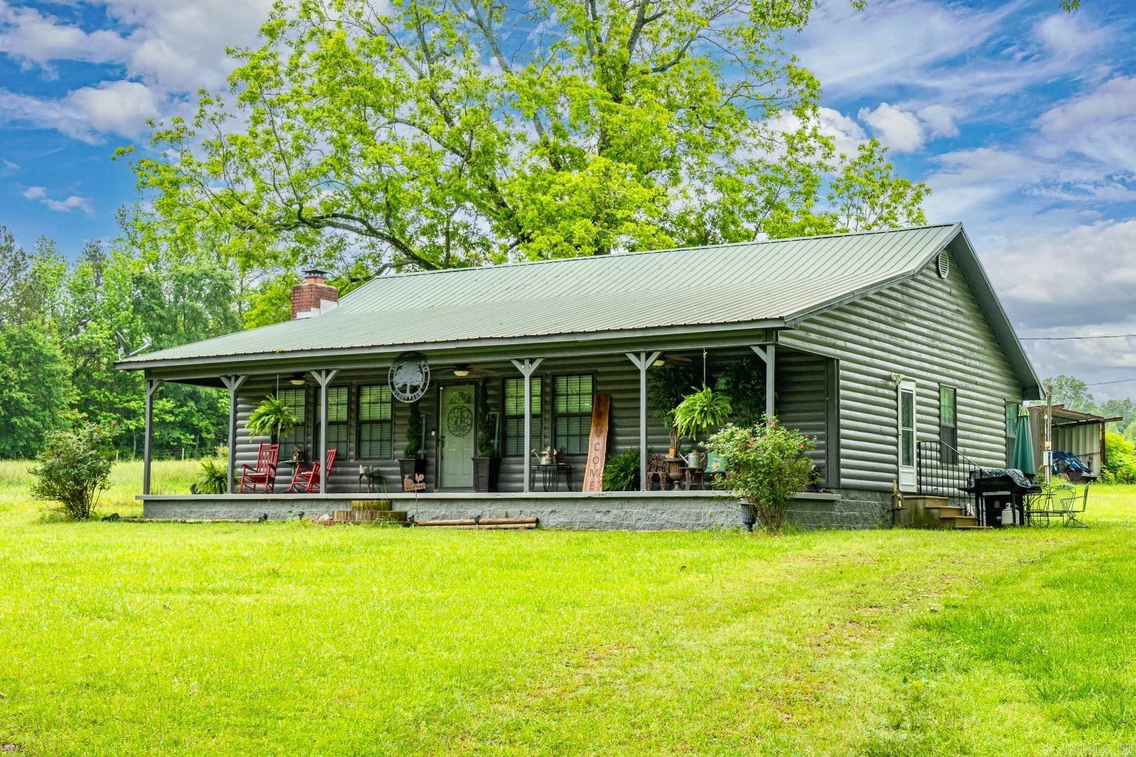Escape to the peace and privacy of this beautifully maintained log cabin nestled on nearly 13 acres of picturesque countryside. Just 15 minutes from Crater of Diamonds State Park and 30 minutes from Lake Greeson, this unique property offers the perfect blend of rustic charm and modern comfort. The spacious layout includes a LARGE bedroom with ensuite bath, full guest bathroom with a separate laundry area, sunroom, and an open living area perfect for relaxing or entertaining. Outside, enjoy the serenity of your own private pond, cross-fenced acreage ideal for livestock or hobby farming, and wide-open views. A 2-year-old Bosch HVAC system ensures year-round comfort, and farm equipment is negotiable for those looking to jump right into rural living. This furnished country retreat is move-in ready. Whether you’re looking for a weekend getaway or a full-time homestead, this one-of-a-kind property has it all.
