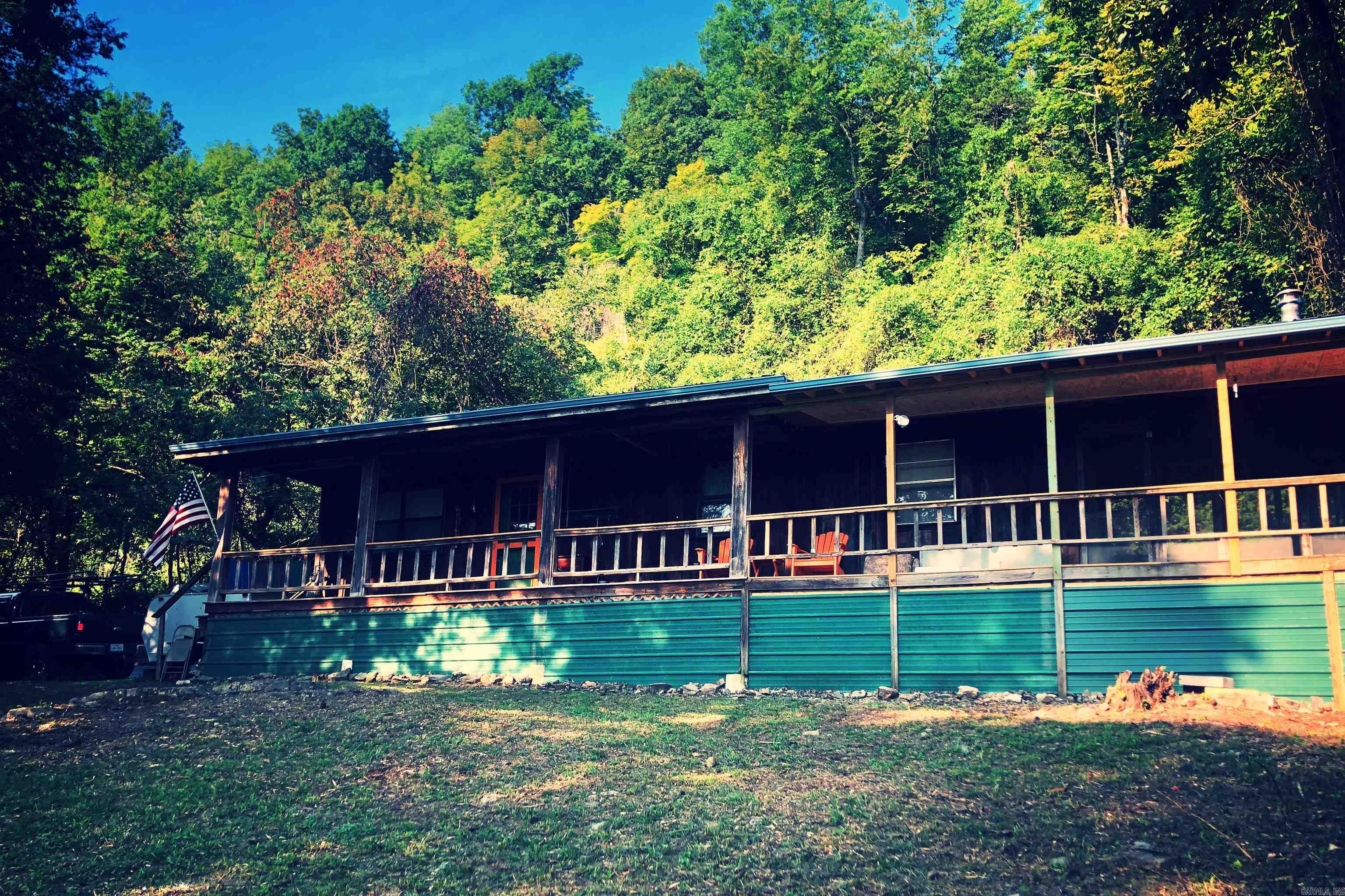A DREAM COME TRUE!! Cozy, MOVE-IN-READY 792 sqf CABIN IN THE WOODS on 3.23 acres m/l WITH STUNNING OZARK MOUNTAIN VIEWS (1,100 elevation) FROM THE 40 ft long FRONT PORCH & A PEACEFUL SCREENED-IN BACK PORCH that is nestled in the back among large rock formations. This cabin is located in a DARK SKY DESIGNATED LOCATION, with no city lights interfering. If you like to hike, you would never have to leave this property. The land offers bluffs to climb & the exploring never gets boring. This 1 bed, 2 full bath retreat has SEASONAL WATERFALLS & a never ending ABUNDANT AMT OF WATER coming down the bluff from a year-round spring on an adjoining landowner. It is PRIVATE, NO RESTRICTIONS, & HUNTING IS ALLOWED, making it perfect for outdoor lovers or investors. Would make a great FRBO (has history of AirBNB revenue) or full-time home, FIBER INTERNET AVAILABLE, —just 15 MINUTES FROM THE BUFFALO NATIONAL RIVER put in at Grinders Ferry location for floating, hiking, & exploring. A sweet spot for adventurous folks who enjoy small-town living with big nature vibes. Located about 8 miles from Marshall, AR. CALL TODAY & make this your OWN MOUNTAIN ESCAPE!! 4wd recommended