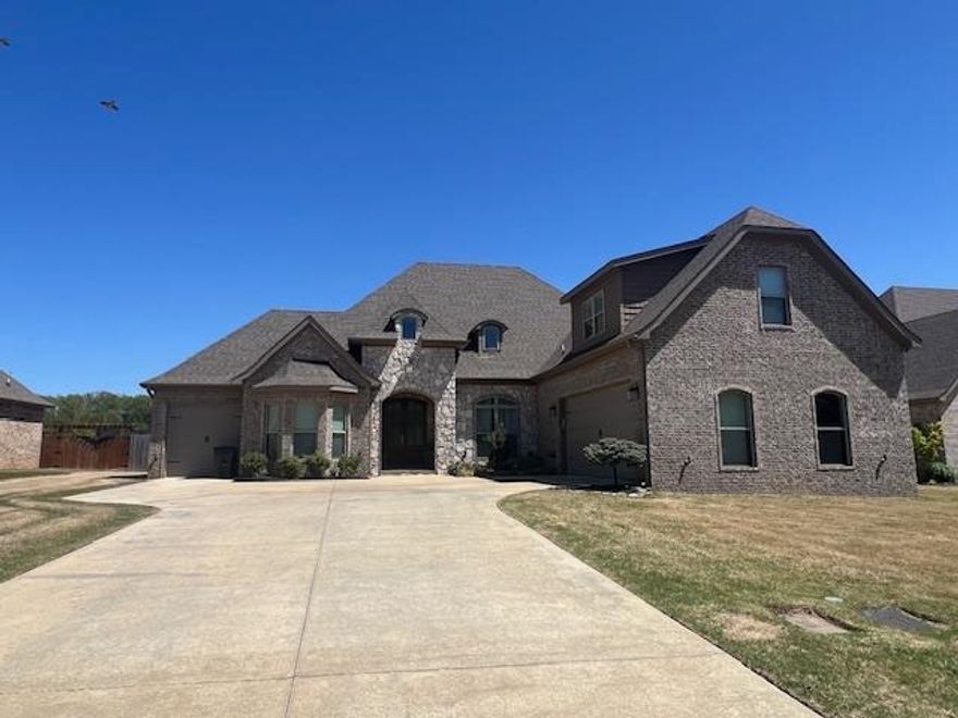 This thoughtfully designed home is ideal for a growing family, offering both functionality and comfort. Enter through the garage to find a mudroom/laundry area and a nearby half bath.  The open-concept kitchen features ample cabinetry and flows seamlessly into a vaulted living room, highlighted by a beautiful stone fireplace with a cedar mantle. Step outside to enjoy a spacious covered back porch with an extended patio and a generously sized backyard, ideal for outdoor gatherings. The second and third bedrooms are well-proportioned and share a bathroom equipped with a dual-sink vanity. On the opposite side of the home, the private primary suite offers a peaceful retreat with a luxurious en-suite bathroom, complete with a soaking tub, separate tiled shower, and a walk-in closet. Upstairs, you'll find a versatile bonus space enhanced by a full bathroom and a walk-in closet perfect as a fourth bedroom, media room, or home office, with convenient access to the main level.