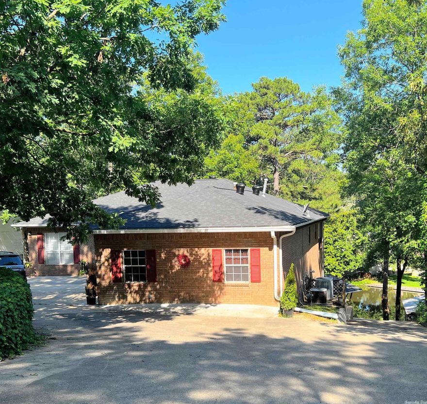 Unique 4200 sq ft Lake Home has 2 complete living and cooking areas.  Master bedroom and bath are on the walk in level with access to a stunning deck.   1 additional guest room & bath.  Huge utility room off oversized double car attached garage.  Living area features a fireplace, lovely hardwood floors and access to a covered deck.  Downstairs features 2 bonus areas, kitchen, 2 bedrooms and 1 bath.  Paved boat launch; covered 2 slip boat stall, covered carport and extra storage building.