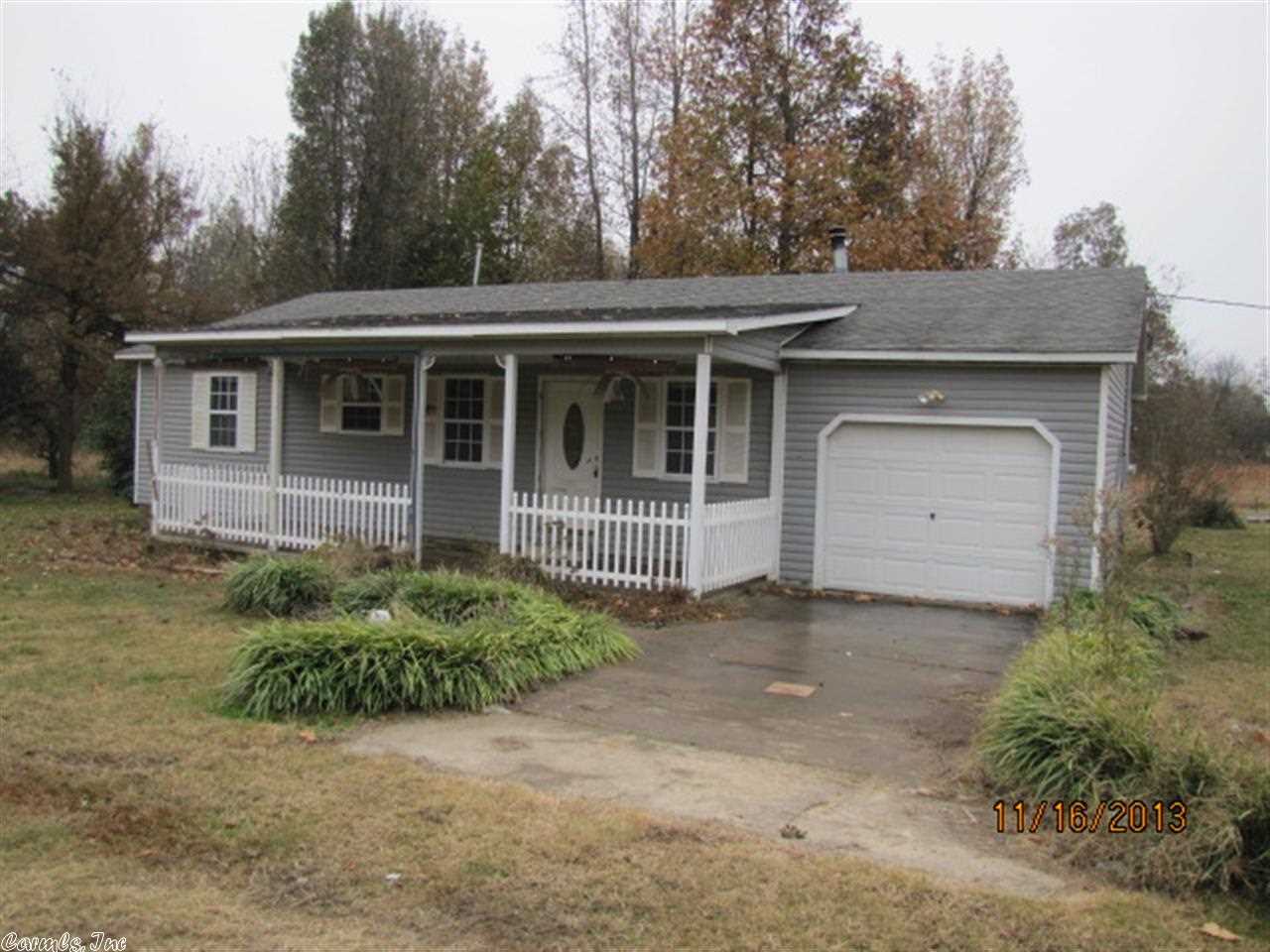Attractive two bedroom two bath home on 18 secluded acres north of Rector. Central HVAC, but outside air unit is missing. Tile floors in kitchen, laundry and both bathrooms. Kitchen appliances are missing. Ceramic tile pad and vent in living room for wood burning stove, but stove is missing. Single car attached garage, and a large covered front porch that has been screened.