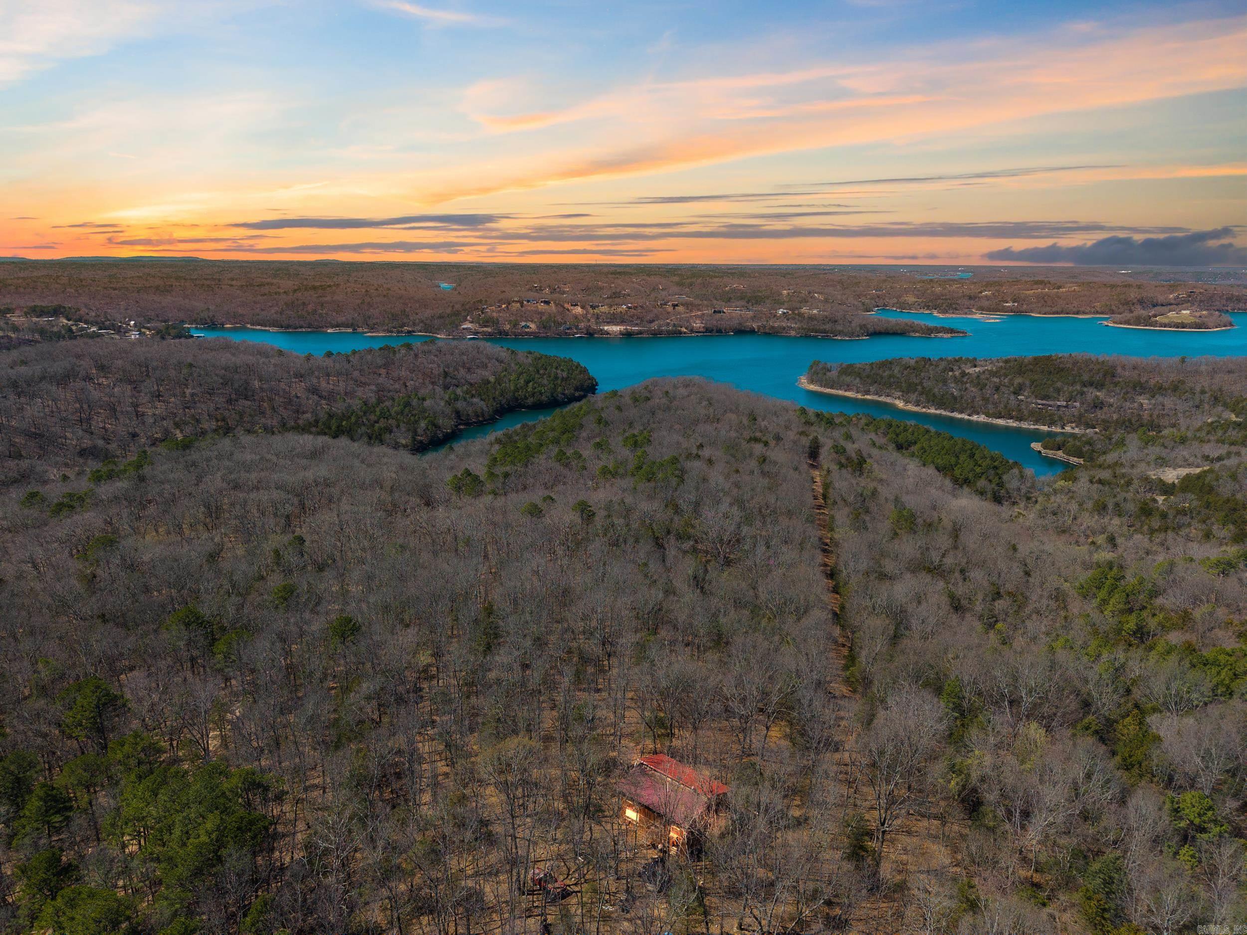 *PRIVACY!* 71.82 acres of natural beauty with a cozy cabin and 681 feet of lake frontage that is level/gently sloped, on one of the deepest coves on the lake, offering seclusion and easy access to three boat launches! The mostly wooded land features marketable timber and is ideal for hiking, camping, or building your dream lake home. Split the land to recoup investment or simply enjoy the peace! Adjacent Corps of Engineers property ensures more untouched nature. Abundant wildlife thrives here, offering great hunting and fishing opportunities! The adjoining 80 acres of Corps property provides more room for hunting and exploring! Rural Water is available, and the 2,560 sq. ft. rustic cabin has many custom features and is built tough with strong 6x6 post construction with southern yellow pine. With 1-foot thick walls, Itās easy to heat/cool! Flooded with natural light, it offers 29 windows on the first floor and 46 on the second, providing beautiful views. Decks: 48'x8' and 12' on the first floor, 8'x24' on the second. If you're primarily looking for acreage, this property can be divided with 60 acres featuring prime lakefront frontage without the cabin, for $678,400!