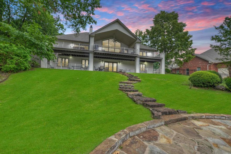 Modern 4,560 SF lakefront home with panoramic views in one of Hot Springs' most desirable neighborhoods. Features include triple-car garage, chef’s kitchen with black granite & high-end stainless appliances, double-sided gas fireplace, and main-level primary suite. Walls of glass open to expansive deck; lower level offers 3 guest rooms, 2 baths, 2nd living area, kitchenette, wine storage, and walkout to covered patio & fenced dog run.  Recent upgrades: new roof, gutters, exterior paint, carpet, and fencing (2024-2025). Includes 2-stall covered boat dock with hydraulic lift & PWC pad. Gated community with pool, clubhouse, tennis/basketball courts, boat ramp, and RV storage. No short-term rentals. HOA $700/yr.