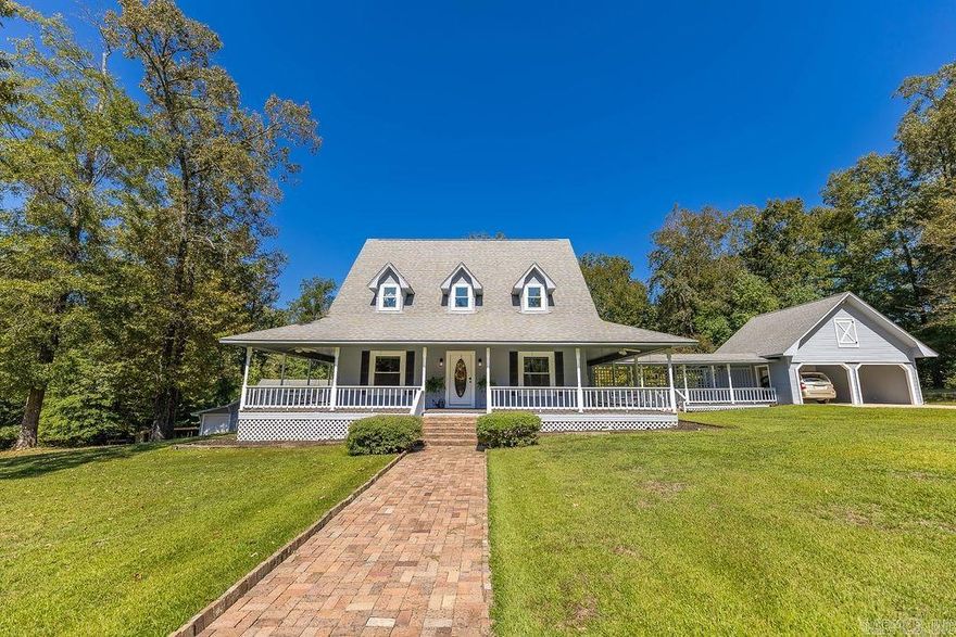 Welcome to your dream retreat - a stunning modern farmhouse nestled on 2.43 acres of a landscaped paradise. This captivating home perfectly blends rustic charm and refined luxury, offering an inviting wrap-around porch, and open-concept kitchen and living area designed for both comfort and entertaining. On the main floor you will find beamed ceilings, a cozy fireplace, separate dining room, study, bonus room, and a beautiful kitchen with granite countertops and island, as well as a breakfast nook that overlooks a sparkling saltwater pool. The spacious primary suite is a true retreat with a custom-designed walk-in closet, master bath with double vanities and elegant finishes.  Additional bedrooms and bathrooms allow for guest to have a comfortable stay as well as privacy.  There is a flex space that currently serves as an office and sitting area which can easily be converted into a fourth bedroom.  This extraordinary home offers endless possibilities. A 26X24 shop w/dust collection system for woodworking and a 36X24 building with central heat and air and half bath that can serve as an additional garage or guest suite, a firepit, 2 car carport and lots of curb appeal.