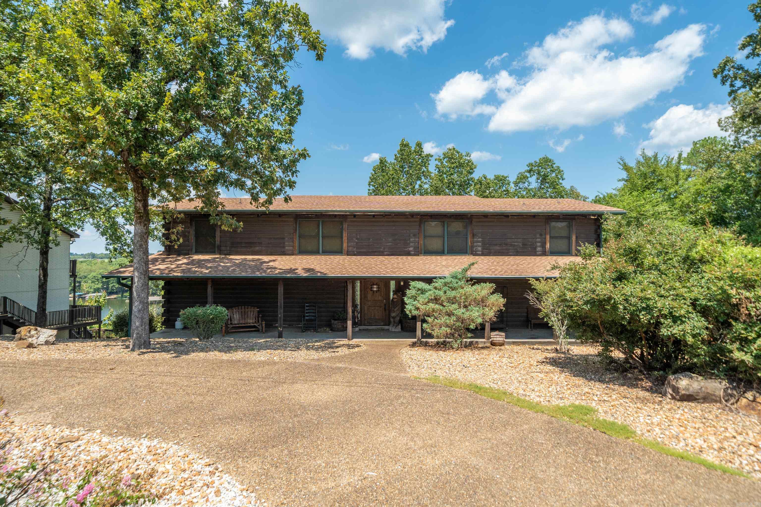 One of a kind lakefront log cabin! This 5 bed, 5 bath home offers a rare combination of space, character, and lakefront living. Every bedroom has its own en suite, providing comfort and privacy for family or guests. The main level features. two primary suites, while upstairs offers tow additional bedrooms with private baths. The lower level includes a second living area with a pool table, plus another bedroom and bath--perfect for entertaining or multi-family use. Vaulted ceilings, spacious rooms, and warm log-cabin charm create a cozy yet grand atmosphere. Step out onto the back porch to take in gorgeous lake views. Selling fully furnished, this home is currently operating as a licensed short-term rental, with the license transferable to the new owner. Ideal as a primary residence, vacation home, or income producing property.