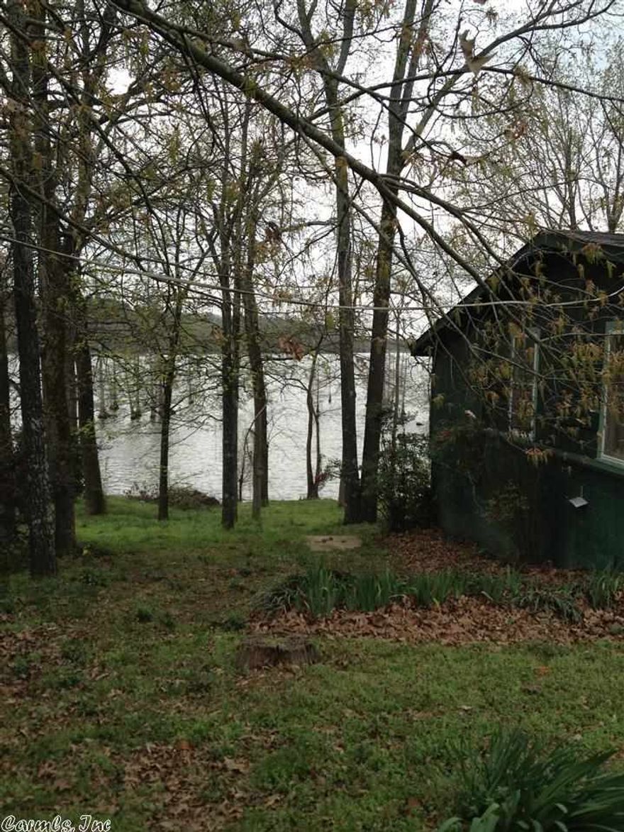 Rustic retreat on Lake Conway.  103 feet of lake frontage along picturesque shoreline.  Over ½ acre gently sloping to the water.  Beautiful mature hardwoods and natural habitats combine to create a bird watchers’ paradise.   Cabin has fully equipped kitchen with dishwasher, trash compactor, built-in range and microwave.  Open kitchen, dining and living area.  Native rock wood-burning fireplace.  Sleeping porches have been enclosed and provide extra bonus rooms overlooking the lake.  See agents remarks.