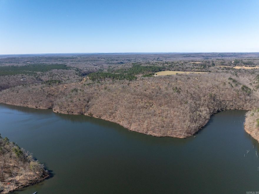 Red Bluff on Barnett Lake offers some of the most stunning vista views in the region. With over a mile of frontage along Barnett Lake, the property features panoramic views from the “Red Bluffs” on the east side. The elevated terrain provides sweeping sightlines across the surrounding landscape, capturing the beauty of the northern Ozarks in central Arkansas.  This property showcases exceptional scenery with a diverse mix of land features, including approximately one mile of lake frontage, mixed pine and hardwood timber, and an open field near the center of the property. The combination of habitat and water access supports outstanding wild turkey and deer hunting, along with direct fishing access on Barnett Lake.  The property also presents strong potential as a venue site, with access off Gravel Hill Road near Floyd. Its location places it less than 45 minutes from Little Rock and under 40 minutes from Conway. An improved interior road provides access to the central portion and multiple potential building sites.  Whether for recreation, a private retreat, event venue, or future homesite, this property stands out for its topography, water frontage, and expansive views.