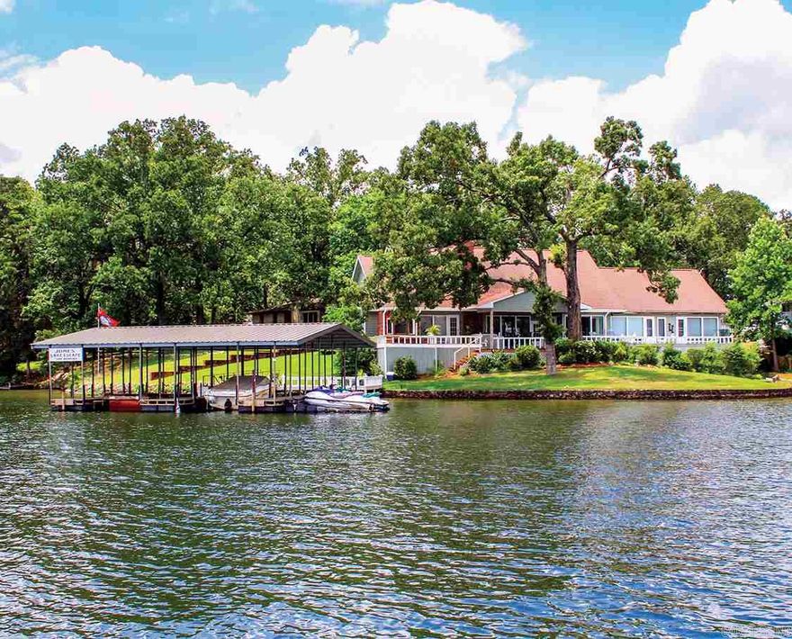 This is an one-of-a-kind lake home nestled on a tree covered lot at the end of a dead-end street, with a Million Dollar unencumbered view of the main lake channel with the rear of the house facing the east. The kitchen, dining & main living areas are wide open flowing space with a wood burning fireplace. There is a separate living quarters/game room & a large office with a full bath that could easily be used a another bedroom. The entire back of the house features a spectacular lake view. 2 stall boat dock