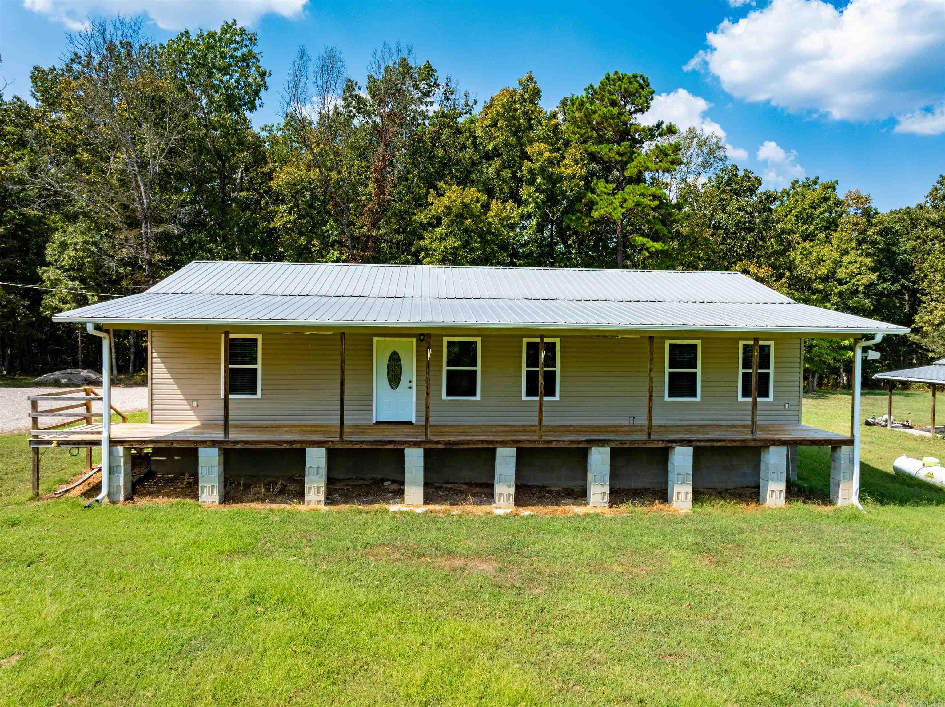 Charming custom home on 20± acres with pond, porches & privacy—minutes from Cave City, AR. Built in 2019 and tucked just off a paved road for easy access, this single-level home offers approx. 1,728 heated/cooled sq ft with a warm, open-concept layout and custom finishes throughout. Enjoy a full-length front porch and a screened-in back porch overlooking your private acreage. Interior: 2 bedrooms • 2 full baths, open living/dining, custom cabinetry with large island, and a spacious laundry room. Abundant natural light frames peaceful countryside views. Land: 20± acres with a nice front pond, fenced acreage suitable for a horse or livestock, gently rolling pasture, and mature shade trees. Utilities in place—turnkey and move-in ready. Whether you’re sipping coffee on the porch, watching wildlife by the pond, or building a small hobby farm, this property delivers peace, privacy, and possibility close to town.