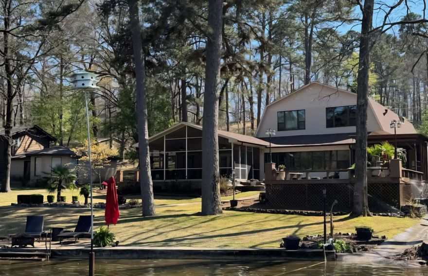 LOCATION! Rare availability in this coveted lake location. GARVAN GARDENS is directly across this large cove off main channel. Within 20 minutes to I-30. 2 stall covered boat dock with swim deck. Rock sitting area lakeside with easy walk out lake access.. Picnic table, palm tree and beautiful landscaping makes for the park like setting. Outdoor kitchen/cabana & RV hookup/parking. PLENTY of room! A split level with major lower level remodel to studs/concrete. Significant updates to the newer, upper level. Roof and all 3 heat pumps replaced in the last 2-3 years. Upper level has a Mstr bdrm with walk-in closet & laundry along with 2 add'l bedrooms each with full bath. Upper also features a kitchenette, dining/office, large den with gas fireplace and large picture windows. Middle level features an XL 2 car garage with a 1/2 bath and workshop. This same level has an XL room that has been used as an add'l bedroom and/or playroom. A few steps down to lower level finds yet another Mstr bdrm with a XL closet, full bath and sunroom. The main kitchen and den with a gas fireplace are on this level along with an add'l laundry, wet bar, XL pantry and XL 1 car carport. IDEAL!