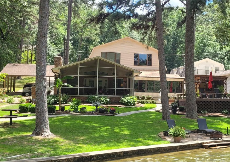 LOCATION! Rare availability in this coveted lake location. GARVAN GARDENS is directly across this large cove off main channel. Within 20 minutes to I-30. 2 stall covered boat dock with swim deck. Rock sitting area lakeside with easy walk out lake access.. Picnic table, palm tree and beautiful landscaping makes for the park like setting. Outdoor kitchen/cabana & RV hookup/parking. PLENTY of room! A split level with major lower level remodel to studs/concrete. Significant updates to the newer, upper level. Roof and all 3 heat pumps replaced in the last 2-3 years. Upper level has a Mstr bdrm with walk-in closet & laundry along with 2 add'l bedrooms each with full bath. Upper also features a kitchenette, dining/office, large den with gas fireplace and large picture windows. Middle level features an XL 2 car garage with a 1/2 bath and workshop. This same level has an XL room that has been used as an add'l bedroom and/or playroom. A few steps down to lower level finds yet another Mstr bdrm with a XL closet, full bath and sunroom. The main kitchen and den with a gas fireplace are on this level along with an add'l laundry, wet bar, XL pantry and XL 1 car carport. IDEAL!