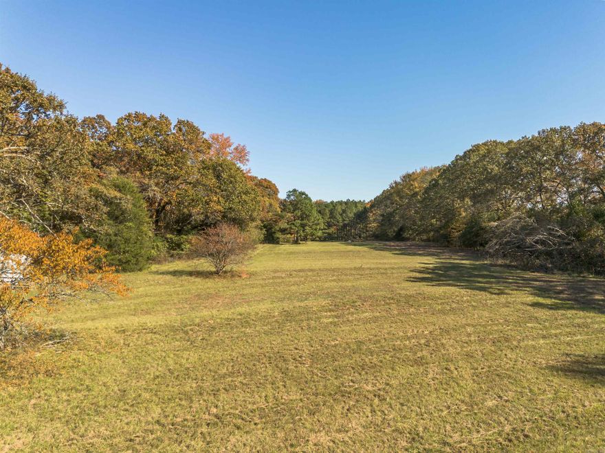 The property includes one pond stocked with fish and a seasonal creek. Well-maintained pasture and existing fencing support livestock, horses, or agricultural use. Improvements include a pole/hay barn with metal roof for equipment or tractor storage. Public water and electricity are available at the road. The land features a variety of mature trees including crape myrtles, oaks, maples, pines, and fruit trees (peach, pear, and plum). No restrictions. Suitable for homestead, small farm, livestock operation, or future homesite development.