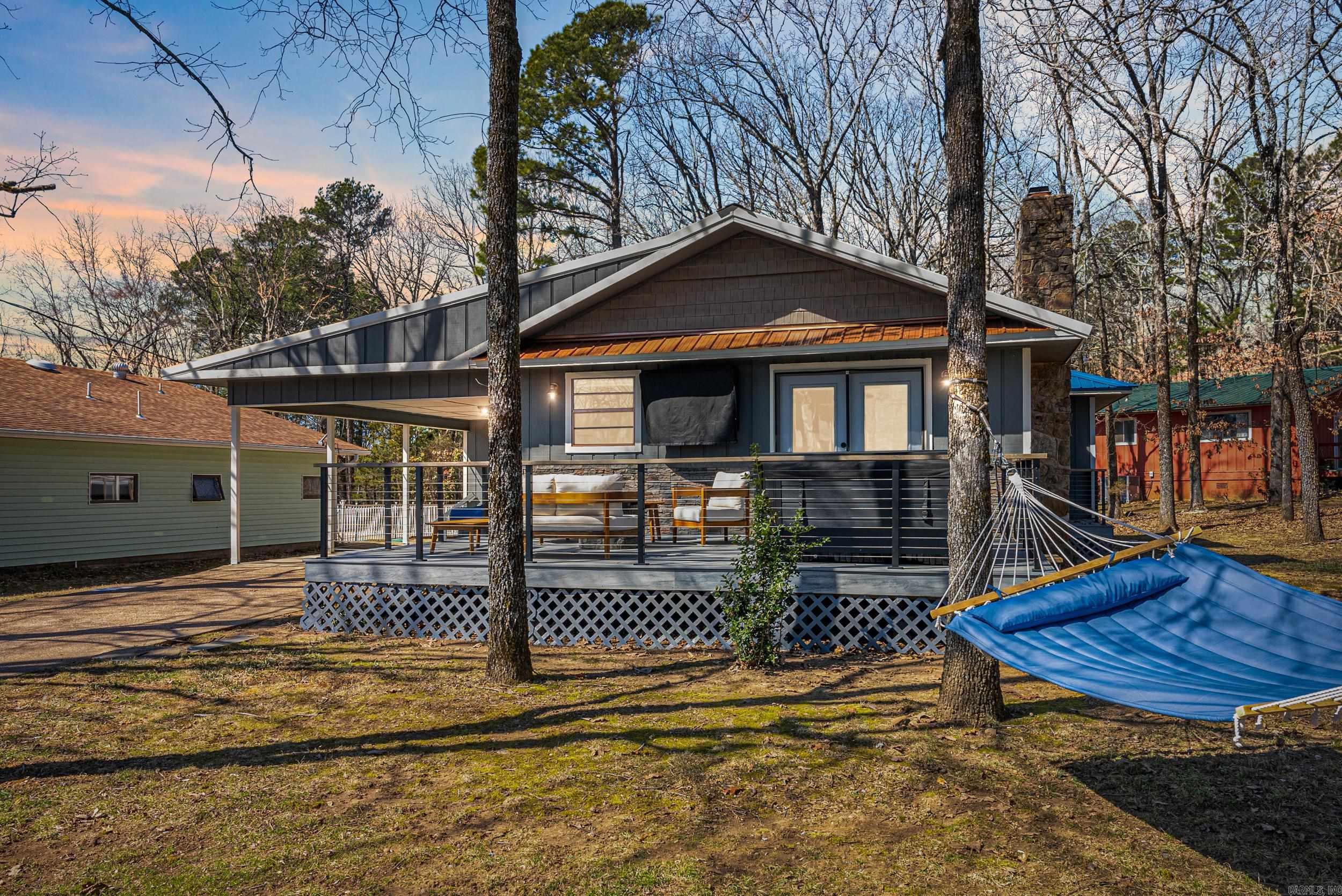 Each morning begins with a masterpiece—your cup of coffee paired with nature’s art gallery, as the sunrise paints a picture-perfect view over Sugarloaf Island & Greers Ferry Lake. This meticulously renovated home is a testament to a touch modern cabin elegance & timeless charm, Every room in this home, including bathrooms & kitchen, underwent a stunning transformation in 2023, ensuring a seamless blend of cabin style & cozy sophistication. The kitchen is equipped with all-new appliances in 2022, where you can prepare meals while savoring the mesmerizing view of Sugarloaf Island & the shimmering lake. The new Trex deck (2023) & front porch (2025) provide the perfect setting for entertaining & relaxation. Enjoy the ultimate "room" of the house...unwind in the new hot tub (late 2024), enjoy the fire table & TV to catch your favorite sports enveloped under a canopy of trees. Distinguished by its interior finishes, all ceilings & wainscoat are either pine shiplap or blue ponderosa pine, & the pine interior doors of this home exudes warmth & distinction in every detail. A new metal roof was installed in 2024 ensuring durability for years to come. Furnishings $15,000. Hot tub conveys.