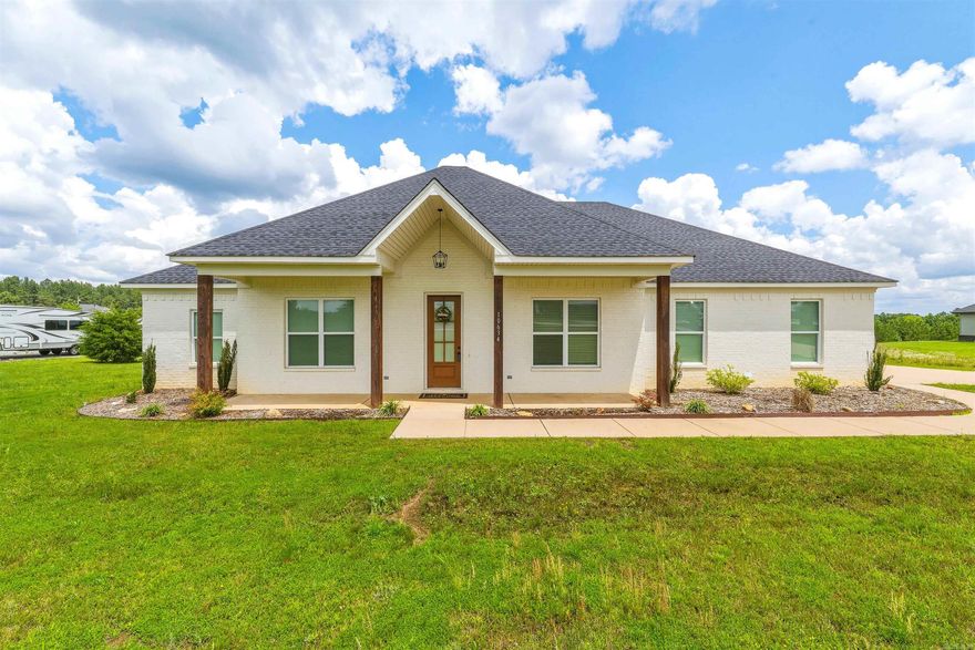 Practically newer build on 1.76 acres — where peaceful country living meets modern comfort. Situated on a scenic homesite with breathtaking views and frequent wildlife sightings, this beautifully crafted 4-bedroom, 2-bath home offers the perfect blend of warmth, style, and functionality. From the moment you step inside, you’ll appreciate the open-concept layout designed for both entertaining and everyday living. The spacious kitchen serves as the centerpiece of the home, featuring a large gathering island, sleek countertops, abundant cabinetry, and upgraded appliances. The inviting family room showcases soaring ceilings with stunning wood beams and a floor-to-ceiling rock wood-burning fireplace that creates a warm and welcoming atmosphere. The private primary suite is a true retreat with elegant beam accents, a spa-inspired bath with a large walk-in shower, and a spacious closet. Step outside onto the covered back porch and unwind while enjoying peaceful sunsets and views of deer roaming the property. With its thoughtful design, beautiful finishes, and serene setting, this home offers the best of country living while still providing modern conveniences. PLUS Qualifies for RD Loan.