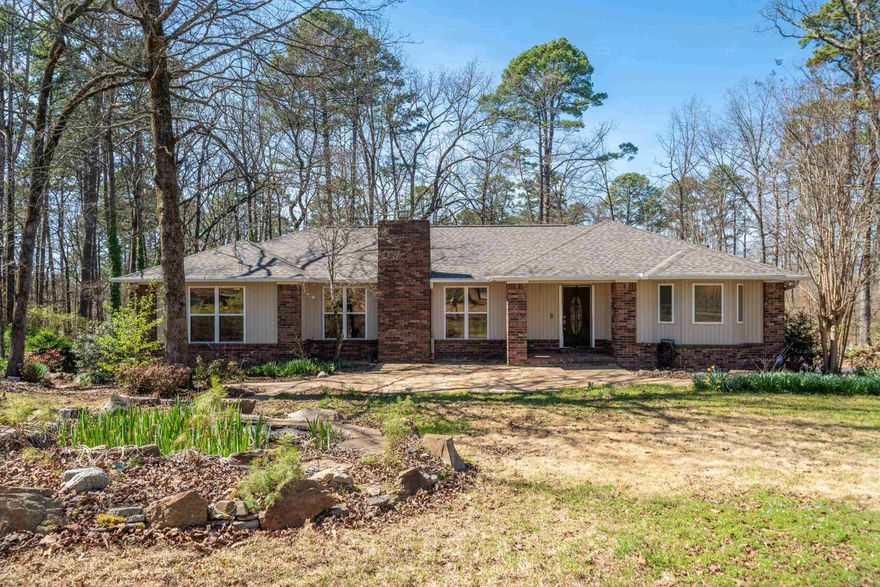 Your future dream home is located just outside Hot Springs city limits! This home has a thoughtfully designed open floorplan with lots of natural lighting!  There are 3 Bedrooms/3 baths on main floor. Spacious master suite with beautiful wood flooring, his and her closets, dual vanities, jacuzzi tub and separate shower. Sunroom/Office area features skylight plus a wall of windows to capture beautiful views. The center of the living room features a cozy fireplace and built-ins.  Spacious Kitchen with full sized dining area, skylight, glass front cabinets, and built-in desk. Finished walk out basement could easily serve as a 4th bedroom or separate living space!  This incredible basement has its own kitchen area with refrigerator, plus convenient outside access. A spacious 2 car garage and a separate oversized golf cart garage with storage area!  Fully Fenced with landscaping and large fountain. All in a natural setting. New roof in 2024, large back deck will easily accommodate numerous sitting areas! This home is perfect for those seeking a serene lifestyle with nearby city conveniences!  Very private corner location! Don't miss this opportunity. Schedule a tour today!