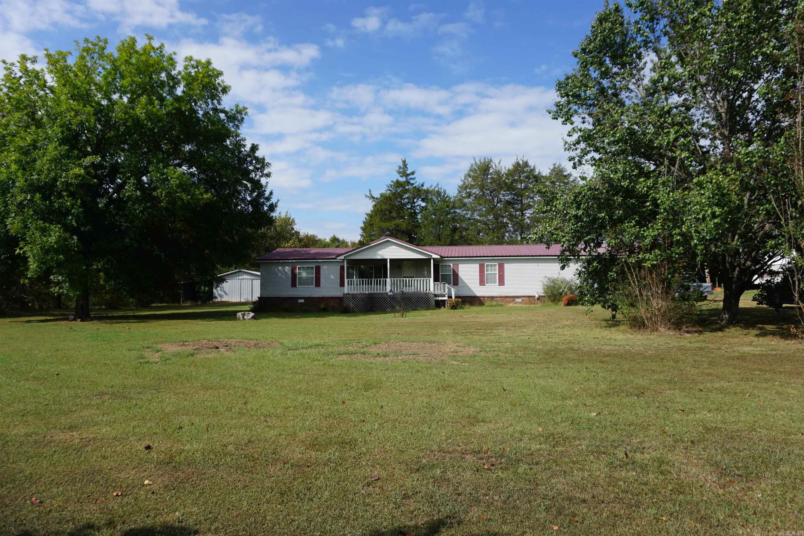 Very well kept 1 owner home sitting on 2 acres just before White County Central School. Large front porch, large concrete porch on the end and an enclosed porch on the back along with a wired metal shop with a concrete floor and a covered storage area, a metal storage building and another storage building. There is covered parking in the back and an RV carport plus a storm shelter and a custom built safe room on the porch at the end of the home. There is a beautiful den, a huge kitchen with a large island, breakfast bar and walk in pantry. The stainless appliances including stove, dishwasher and refrigerator will stay along with a side by side refrigerator. The dining room is right off the living room for a nice open flow. The bedrooms are split and the primary bathroom has a walk in shower. The laundry room is conveniently located off the primary bathroom and the washer and dryer will stay. Sellers are also leaving the video monitoring system that includes 4 cameras. Sellers say the walls are 2x6 and the house is very well insulated. All electric with 5 burner gas heater for backup heat. Laminate flooring put in around 2018 and Metal roof in 2015