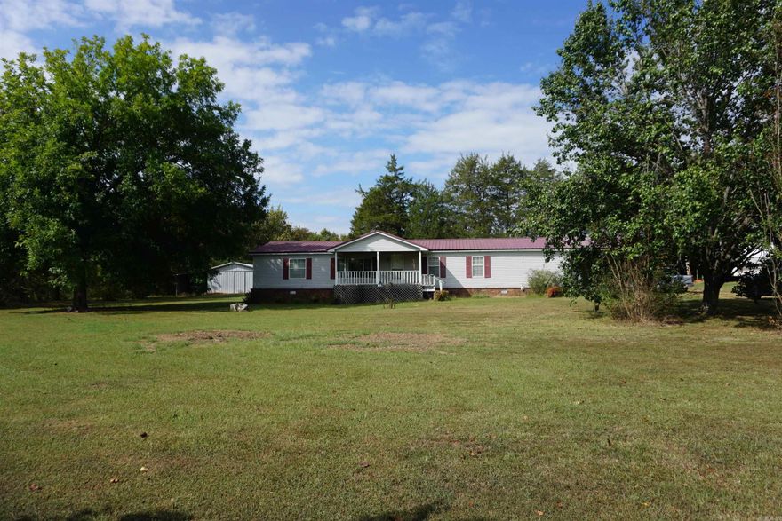 Very well kept 1 owner home sitting on 2 acres just before White County Central School. Large front porch, large concrete porch on the end and an enclosed porch on the back along with a wired metal shop with a concrete floor and a covered storage area, a metal storage building and another storage building. There is covered parking in the back and an RV carport plus a storm shelter and a custom built safe room on the porch at the end of the home. There is a beautiful den, a huge kitchen with a large island, breakfast bar and walk in pantry. The stainless appliances including stove, dishwasher and refrigerator will stay along with a side by side refrigerator.  The dining room is right off the living room for a nice open flow. The bedrooms are split and the primary bathroom has a walk in shower. The laundry room is conveniently located off the primary bathroom and the washer and dryer will stay. Sellers are also leaving the video monitoring system that includes 4 cameras. Sellers say the walls are 2x6 and the house is very well insulated. All electric with 5 burner gas heater for backup heat. Laminate flooring put in around 2018 and Metal roof in 2015