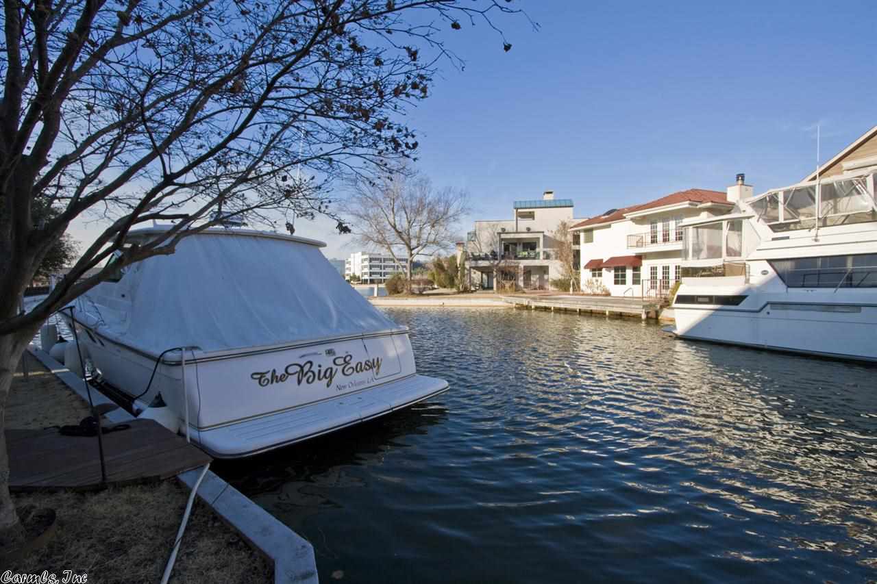 Amazing architecturally significant home built by Jack Hartsell on the Canal with Spectacular views of marina and bluffs. Two story ceilings in family room, handsome decor', arched doorways, French doors to covered veranda, hardwood/limestone floors. Large eat-in kitchen and elegant formal dining. Guest suite on the main level. Luxurious master suite on second floor with stunning views. Wonderful outdoor living space w/ flagstone courtyard and terrace. Third bedrm current library/study. 2 car gar. Gated.