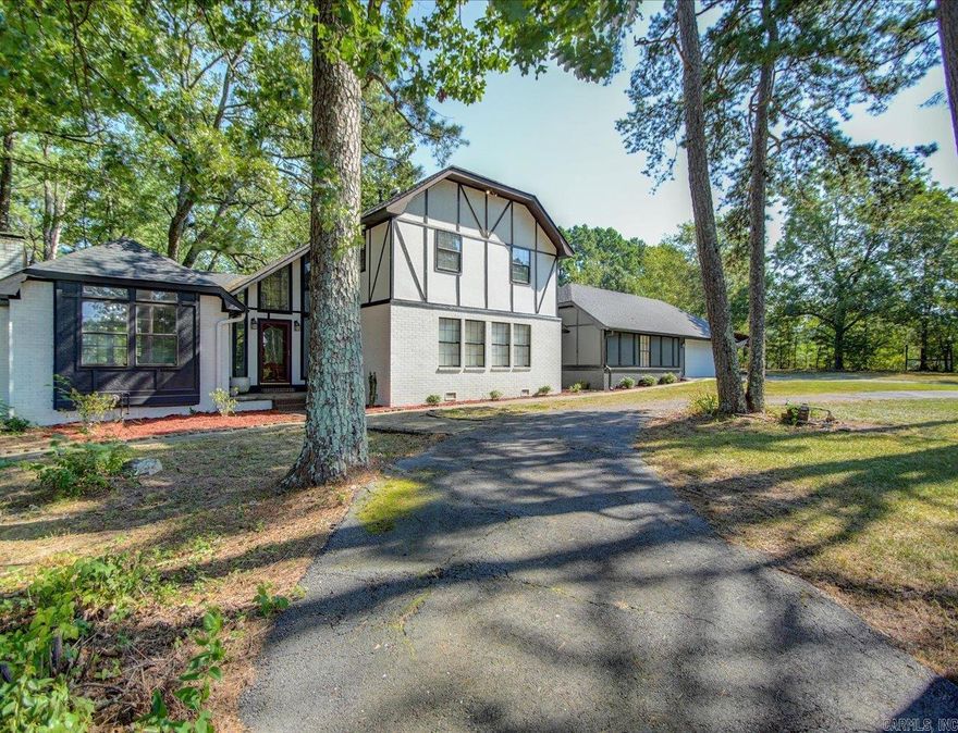 Charming Tudor-Style Home with Pool, Pond & Barn on 4.52 Acres in Lake Hamilton School District! This enchanting Tudor-style residence offers a perfect blend of classic elegance & modern comfort, nestled on a sprawling 4.52 acres within the highly sought-after Lake Hamilton School District. Step inside to discover a beautifully appointed 3Bd/3Ba home that effortlessly combines timeless charm w/ contemporary convenience. The inviting foyer leads you into a spacious, sunlit formal living area w/ vaulted ceilings, intricate woodwork & an exquisite fireplace that serves as the centerpiece of the room. The kitchen is a chef’s delight, featuring rich cabinetry & is open to the dining/family living areas. The home’s 3 bedrooms are thoughtfully located on the upper level, providing a sense of privacy & separation from the main living areas. The master suite is a serene retreat, complete w/ a luxurious en-suite bath, featuring a custom tile shower. The additional bedrooms are well-sized & offer charming details. All this plus an in-ground pool, pond & barn make this the perfect home!