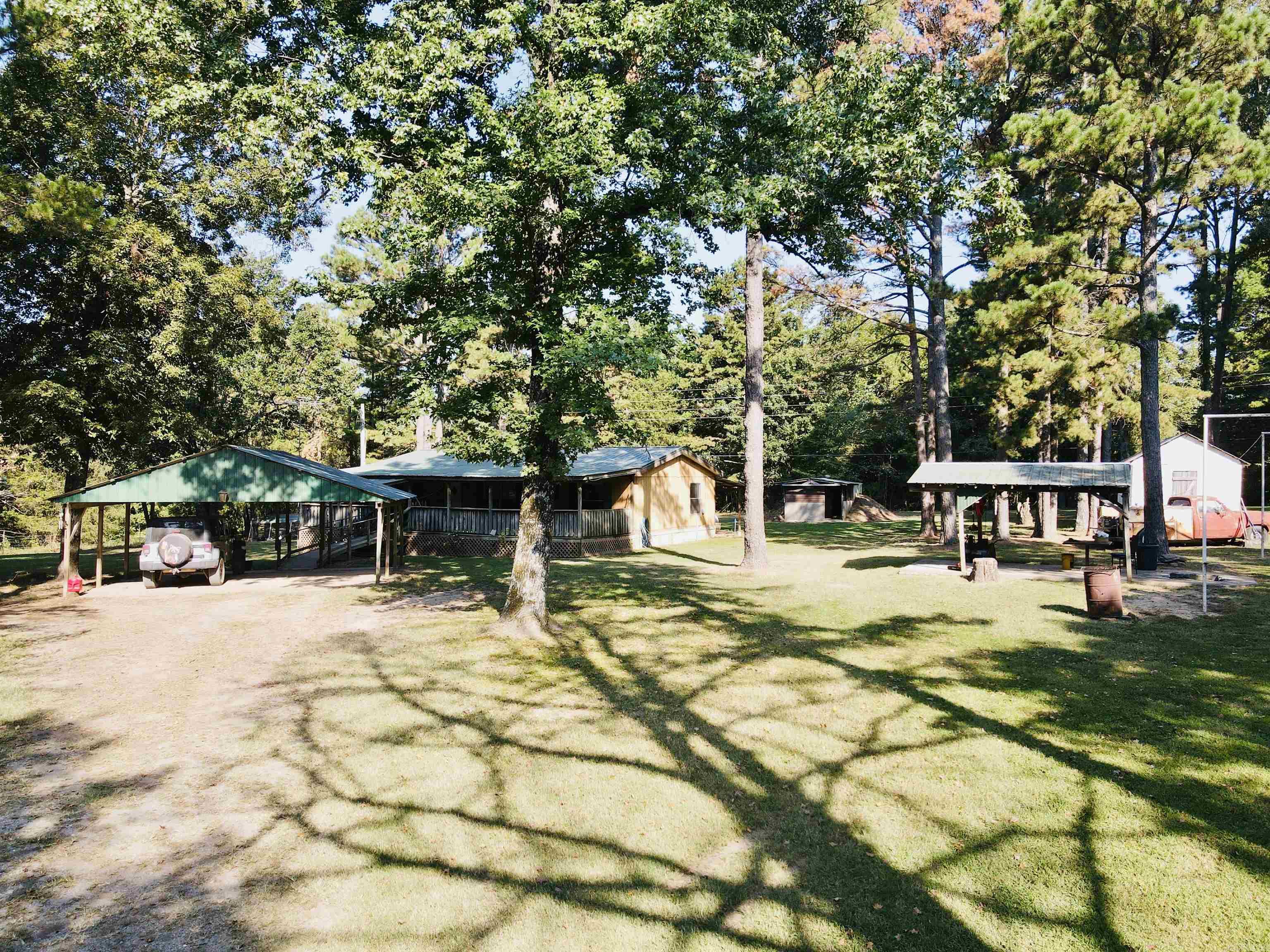 This 3-bedroom, 2-bath manufactured home offers 1,056 sq. ft. of comfortable living space on 3.24 surveyed acres. The property is beautifully landscaped and lays exceptionally well, creating a peaceful and inviting setting. Enjoy the outdoors from the spacious 12x44 covered front deck or entertain under the pavilion. Additional features include a detached 2-car covered carport, tornado storm shelter, city water, septic system, electric, and high-speed fiber internet. With gravel county road frontage, mountain views, and plenty of room to relax or garden, this property combines convenience with country charm.