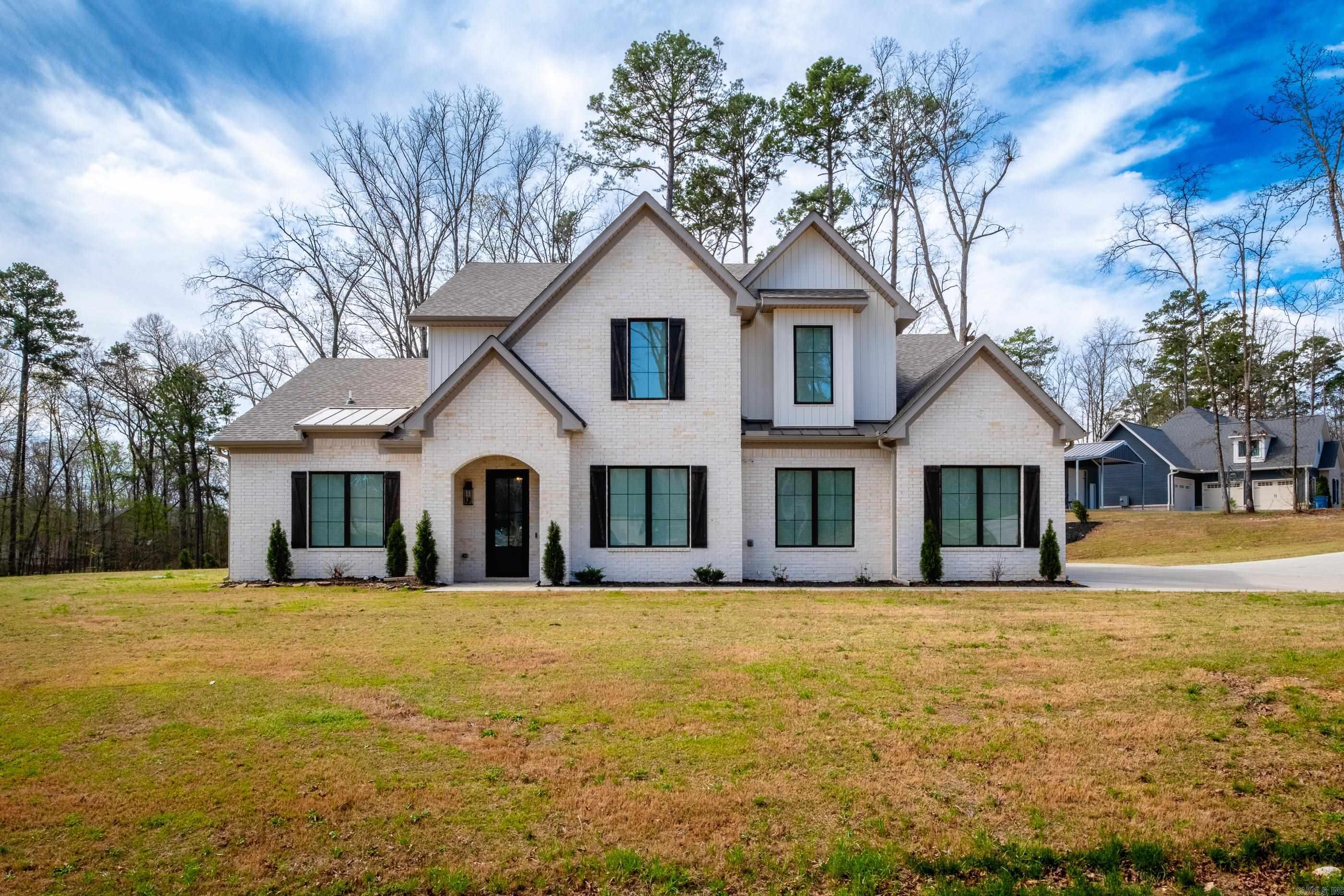 Welcome to your dream home! Nestled on a peaceful 1.5 acre corner lot with a convenient circle drive, you will experience the serene country setting yet only a short 5 minute drive to I-30. Offering abundant storage throughout, a whole-home generator, a 17-zone HVAC system, & a 20X30 brick shop w/ a 10' remote-controlled garage door, this property has it all. Natural light welcomes you into the open-concept living, dining, & kitchen areas, creating a warm & inviting environment. The living room boasts a soaring 24' ceiling and a gas log fireplace, while overlooking a covered patio complete with an outdoor kitchen, wood burning fireplace, and a firepit in the backyard. The primary bedroom features a vaulted ceiling and flows into the luxurious primary bath, complete w/ a walk-through double-head shower fully tiled (including the ceiling) & a soaker tub. The kitchen is a chef's paradise w/ a 36" cooktop, stunning quartzite countertops, custom soft-close drawers & cabinets extending to the ceiling w/ inset lighting, a pellet ice maker, & an oversized island. A spacious pantry even has a countertop & leads to a safe room. This custom-built home is a true testament of thoughtful design.