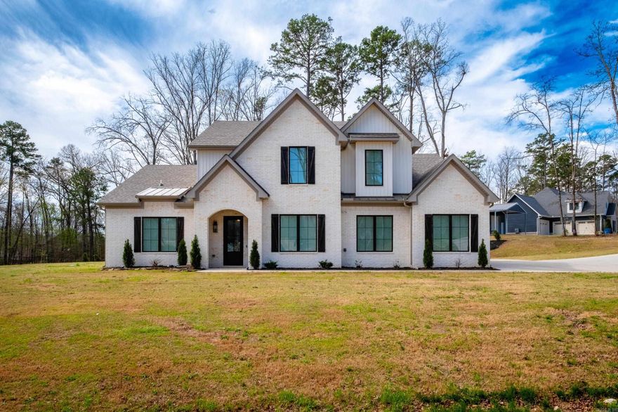 Welcome to your dream home! Nestled on a peaceful 1.5 acre corner lot with a convenient circle drive, you will experience the serene country setting yet only a short 5 minute drive to I-30. Offering abundant storage throughout, a whole-home generator, a 17-zone HVAC system, & a 20X30 brick shop w/ a 10' remote-controlled garage door, this property has it all. Natural light welcomes you into the open-concept living, dining, & kitchen areas, creating a warm & inviting environment. The living room boasts a soaring 24' ceiling and a gas log fireplace, while overlooking a covered patio complete with an outdoor kitchen, wood burning fireplace, and a firepit in the backyard. The primary bedroom features a vaulted ceiling and flows into the luxurious primary bath, complete w/ a walk-through double-head shower fully tiled (including the ceiling) & a soaker tub. The kitchen is a chef's paradise w/ a 36" cooktop, stunning quartzite countertops, custom soft-close drawers & cabinets extending to the ceiling w/ inset lighting, a pellet ice maker, & an oversized island. A spacious pantry even has a countertop & leads to a safe room. This custom-built home is a true testament of thoughtful design.