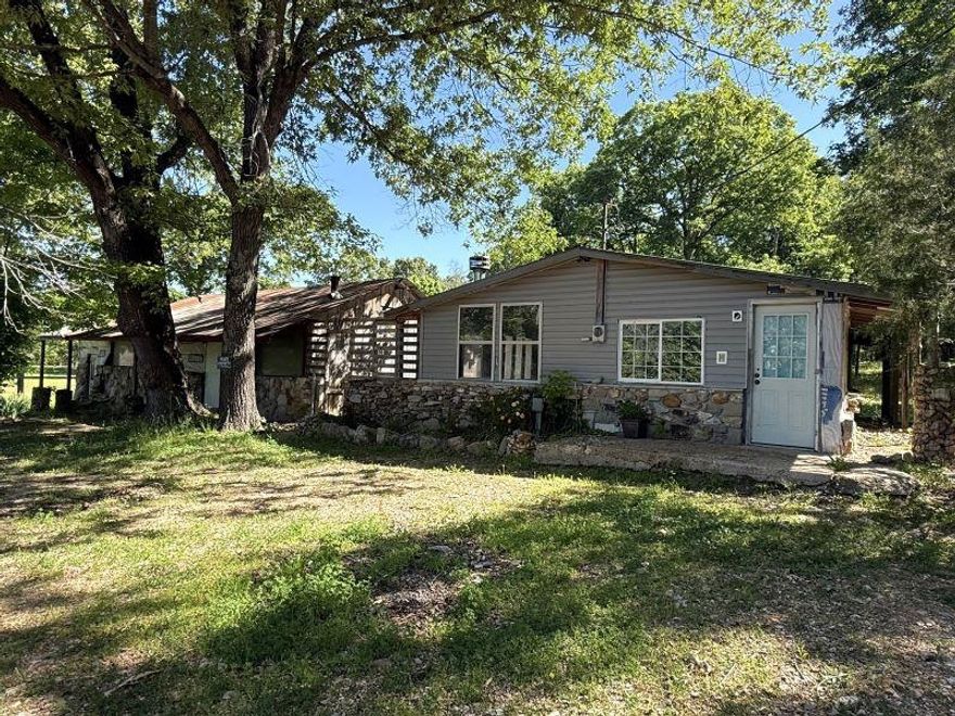 The home and building might need a little love, but the setting is beautiful! Recently surveyed in April 2026, the 2.025 acres feature mostly open land, with scattered trees throughout, a well, electricity, and some fencing.  The home is a 2 bedroom, 1 bath. The building part could be made in to part of the residence, or you could use it for a workshop, a business, or whatever your heart desires! The circle drive makes it easy to get in and out. This property has lots of potential, with a gorgeous setting!