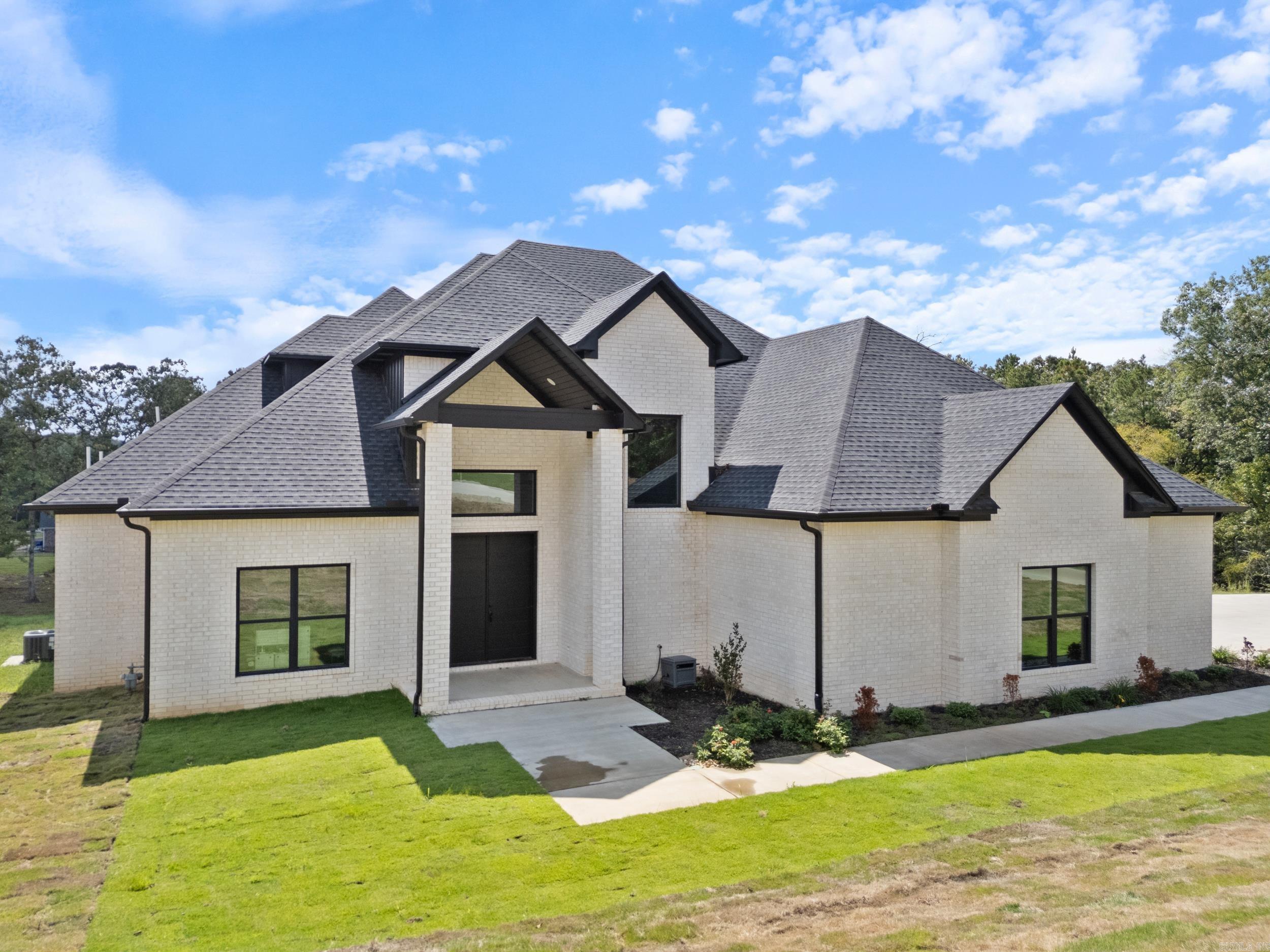 Built in 2023, this contemporary home, on 2.54 acres within Conway city limits, complete with Conway Corp utilities is a must see. You'll love the 22-foot ceiling, natural light, and marble floors in this 5-bedroom, 4.5-bath home. Located just minutes from the interstate, this house is located in Northwoods Estates, a gated community with only 12 lots. The spacious downstairs master suite features a soaking tub, double vanity, walk-in rain shower, and his-and-hers custom closets. Two additional downstairs bedrooms each have their own private full baths. A unique guest/in-law suite is accessible via a private staircase off the garage, leading to a large bonus room, bedroom, full bath, and office, perfect for guests or multigenerational living. The kitchen includes stainless steel appliances, double ovens, a wine fridge, a walk-in pantry. The laundry room has tons of storage & sink for added convenience. Step outside to enjoy the expansive covered back porch. This one-of-a-kind property is a rare find in the heart of Conway.
