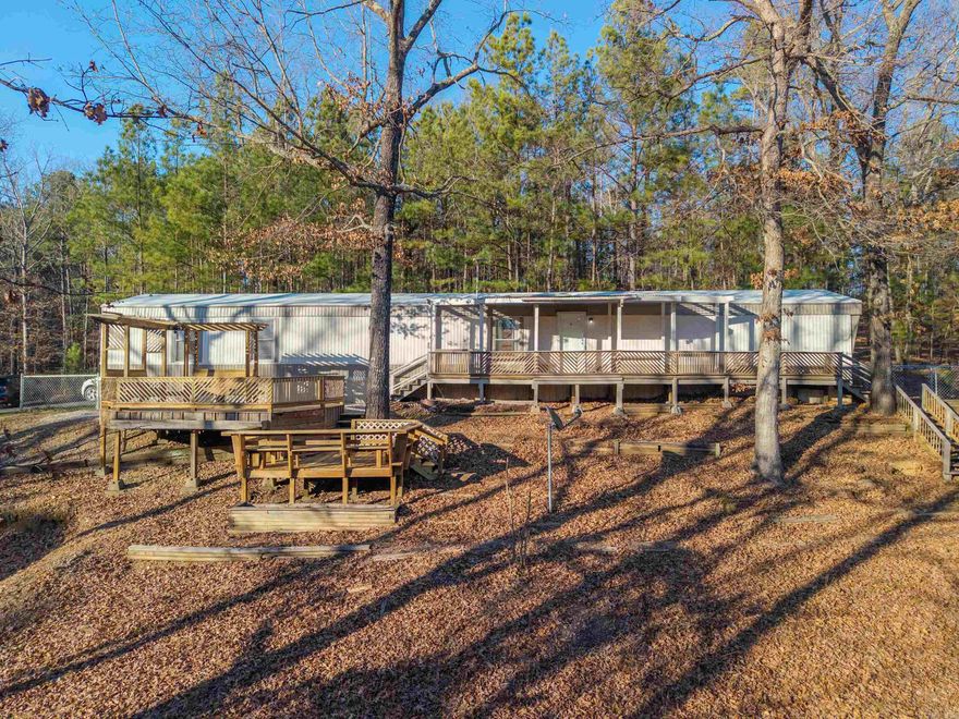 Enjoy privacy, space, and convenience with this well-maintained home on 3.25 wooded acres in the Fountain Lake School District. The property has been recently refreshed, featuring fresh interior and exterior paint, new flooring throughout, a sealed roof, and new gutters. A newer fenced backyard adds functionality for pets or outdoor living.  The home features a bright, open living area and a well-laid-out kitchen with generous cabinet space, offering a comfortable, easy flow for everyday living. Outdoors, multiple decks extend the living space, overlooking a peaceful, wooded setting where deer and other wildlife are frequent visitors — perfect for those who value privacy and room to roam.  Located just 5 minutes from Hot Springs Village and 15 minutes from downtown Hot Springs, this property provides a quiet, rural feel without sacrificing access to shopping, dining, and recreation.  A solid home with recent improvements, land, and a great location.