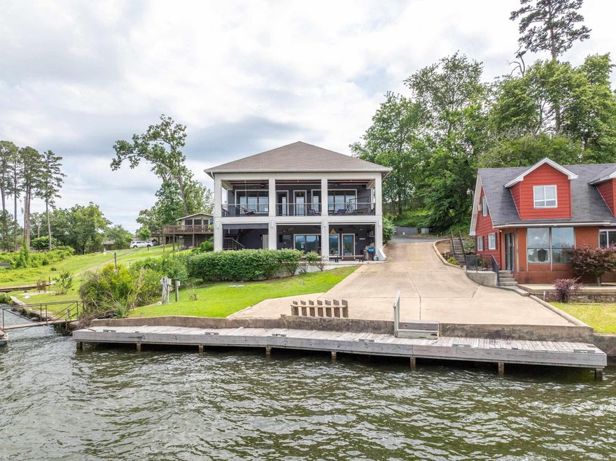 Experience luxury lakefront living in this beautifully designed two-story home on the shores of Lake Hamilton in Hot Springs, Arkansas. With approximately 3,200 square feet of thoughtfully crafted living space, this residence offers the perfect blend of comfort, style, and scenic beauty. Upstairs, you’ll find a spacious open-concept layout where the kitchen, dining, and living areas seamlessly flow together—all while showcasing unobstructed lake views. The kitchen is equipped with Electrolux appliances and ample space for entertaining. The primary suite is also located on the upper level and features its own access to the upper deck, lake views, and a beautifully appointed ensuite bath. A convenient half bath and laundry area round out the upper floor. The lower level is designed with flexibility and comfort in mind, featuring a second living room/den, a secondary kitchen area, two additional bedrooms, a full bathroom, a second laundry space, and another half bathroom. Step outside to enjoy an outdoor kitchen, a relaxing hot tub spa, and a boardwalk that spans the lakefront. New roof installed 2024. Currently used as an active STR.