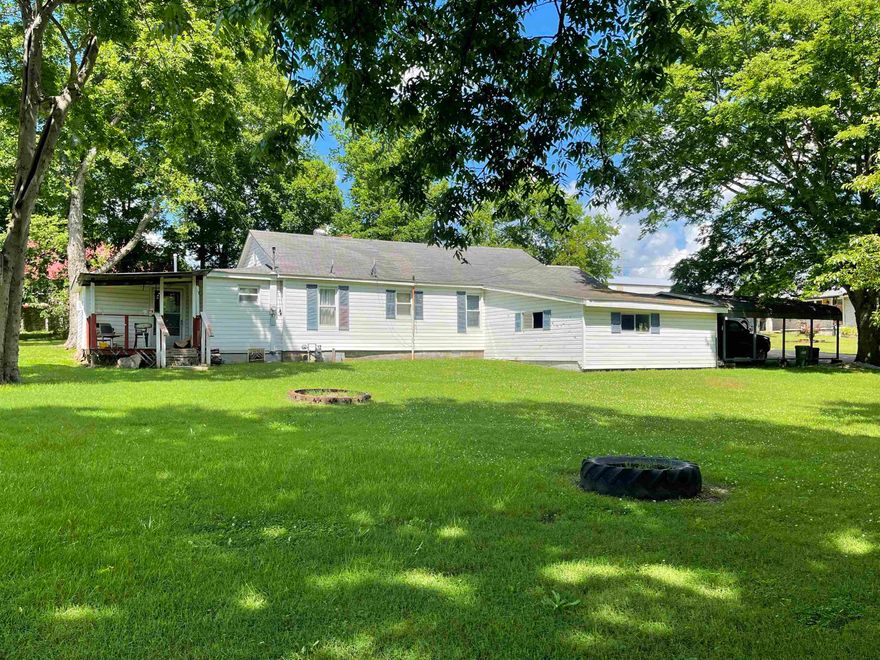3 bedroom, 2 bath home on 3 lots!  The home has newer carpet, central heat and air, and a large utility room! There is a portable carport, an attached lean-to for storage or a workshop, and a storage building.  There is a front porch, as well as a small deck off of the side of the home.  The yard is very large with several, beautiful shade trees.