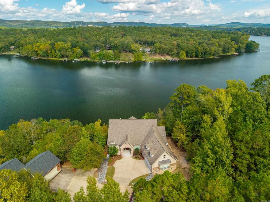 Lake house on Lake Catherine with Spectacular Mountain and Lake Views!!  Enjoy breathtaking views from this beautiful lake home in the Diamondhead Community. Featuring hardwood floors, vaulted ceilings and a chef's kitchen perfect for entertaining.  The main level offers two spacious bedrooms and baths. A double-sided fireplace adds warmth and charm to the living spaces.  Enjoy the peaceful morning and evening views from the two upper decks.  The perfect spot to relax and take in the beauty of both the mountains and lake. A large laundry with additional storage room and a floored attic that offers potential bonus room. The lower level includes a large suite, bath, and a safe room with separate entrance for added privacy.  Storage galore in this home. Conveniently located next door to the marina, making boat parking and lake days easy!