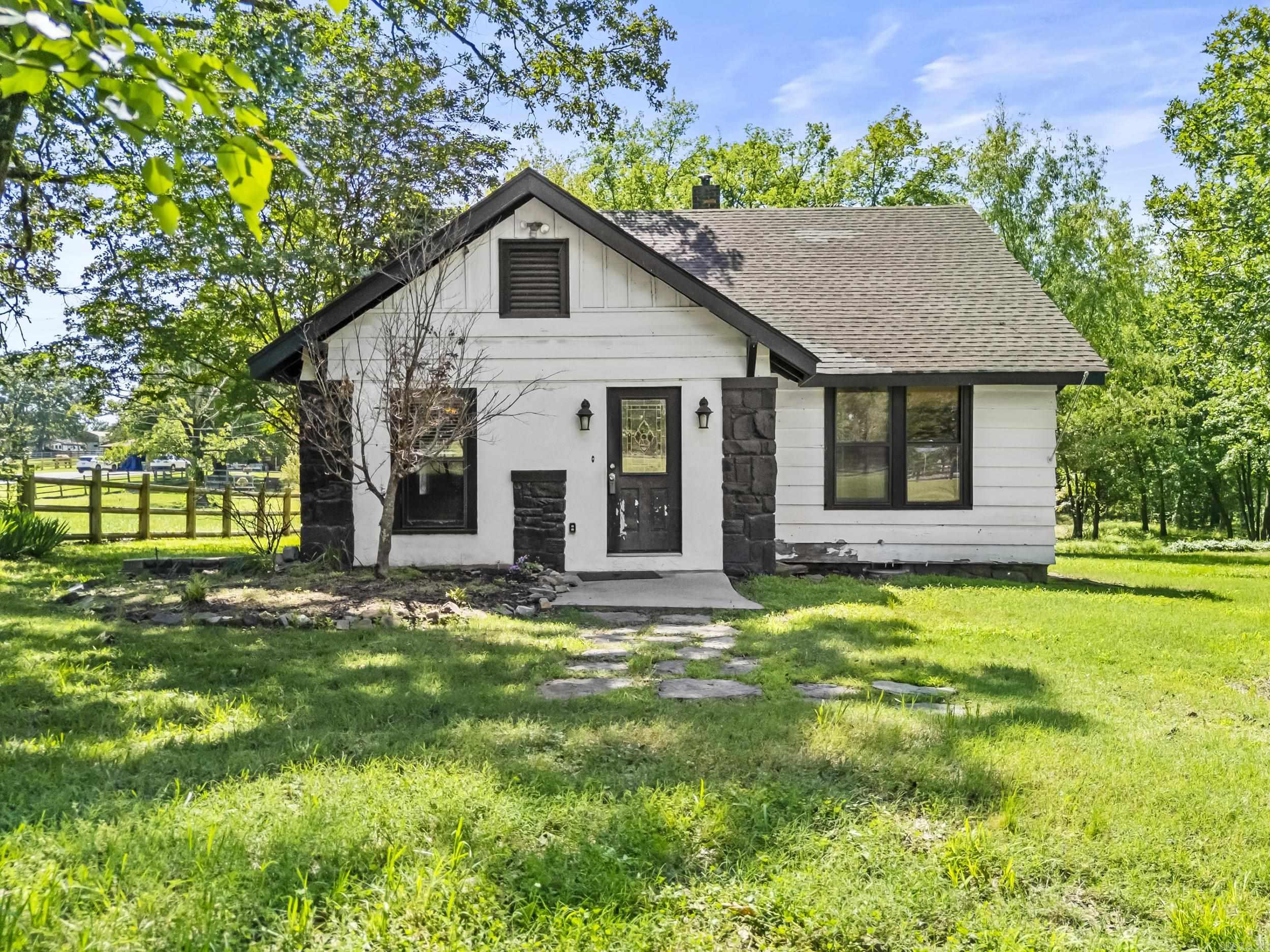 This charming country home, nestled on 2.14 acres of serene land, offers a perfect blend of rustic appeal. The property is fully gated and fenced, providing both privacy and security, making it an ideal retreat. Inside, you'll find a spacious, open living room with tile floors, striking brick and stone accents, recessed lighting, and a cozy wood-burning fireplaceāa perfect spot to relax or entertain. The dining area, featuring hardwood floors and a built-in buffet with extra storage. The kitchen is equipped with a refrigerator, flat surface stove, stainless steel microwave, and dishwasher, along with additional storage space to keep everything organized. Off the kitchen, enjoy a bright and airy sunroom which includes laundry hookups for added convenience. The home offers two bedrooms and a full bathroom on the main level. Upstairs, you'll find two additional bedrooms with walk-in closets, along with a half bath. Beyond the house, the acreage provides room for outdoor activities, gardening, or simply enjoying the land! Donāt miss this incredible opportunity, schedule a showing today and imagine the possibilities for your next home.